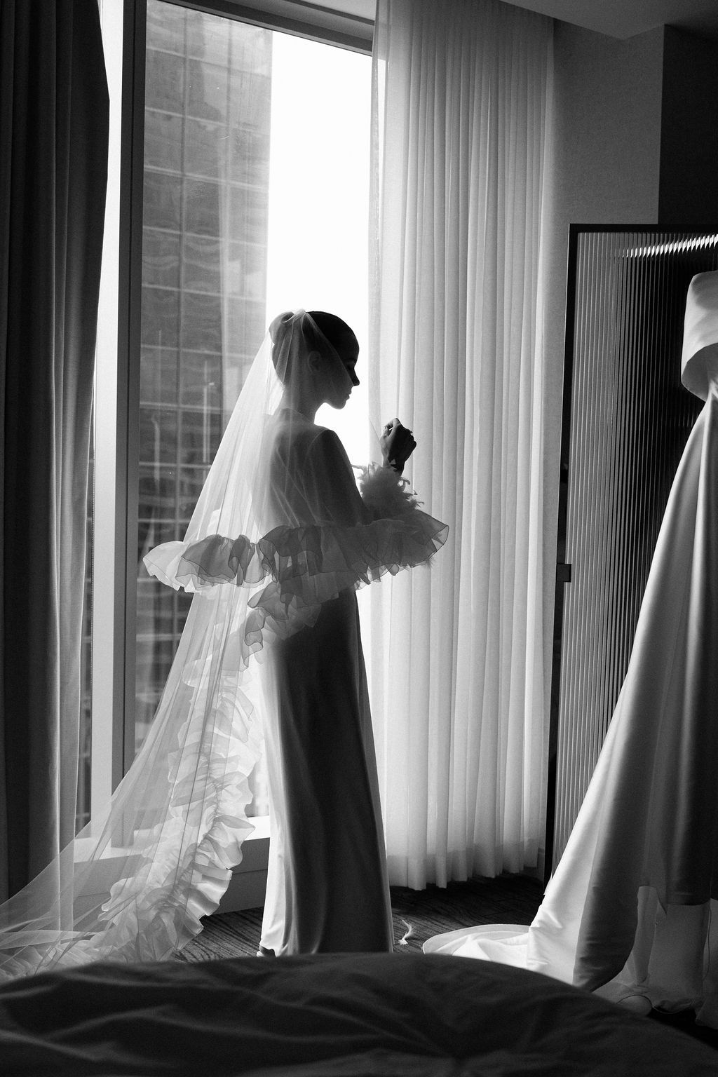 A series of silhouetted bridal portraits against bright windows showing the flowing veil and wedding dress.