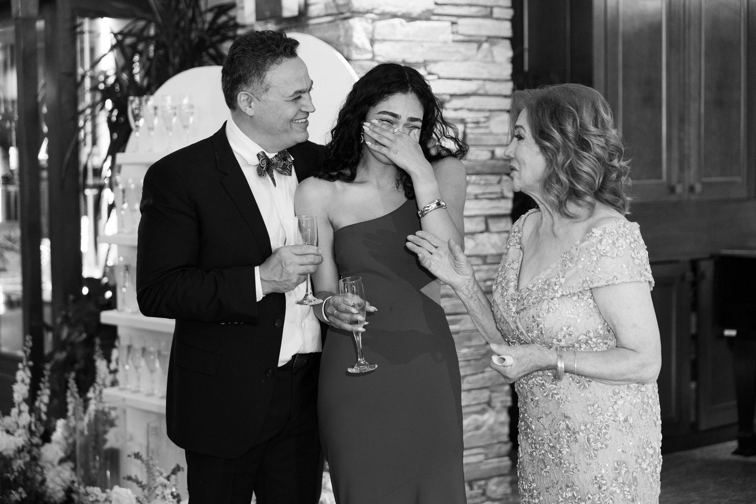 Wedding party members raise glasses in a celebratory toast during an elegant indoor reception.