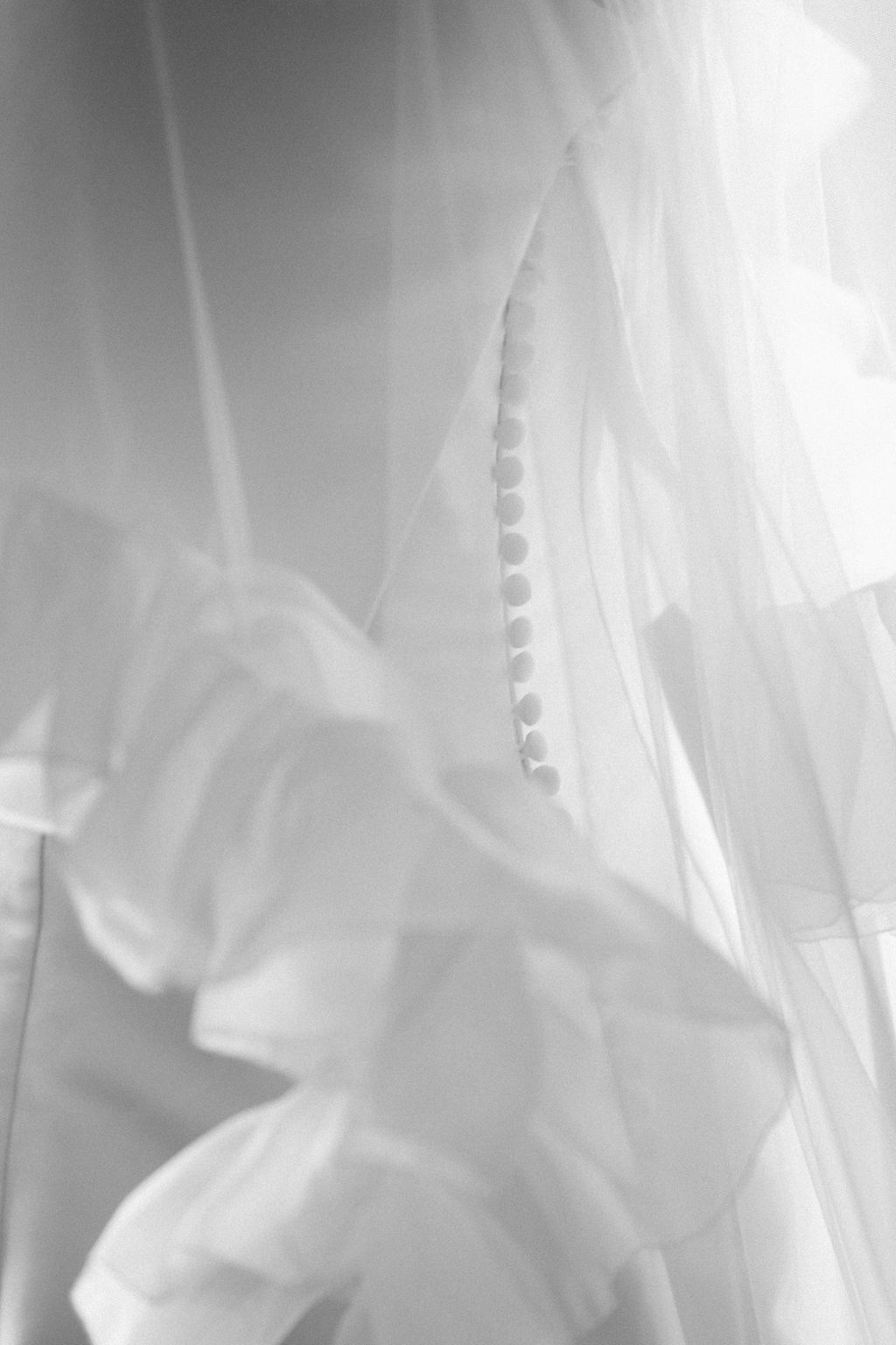 Abstract black and white photograph showing soft flowing fabric with gentle folds and creases in ethereal lighting.
