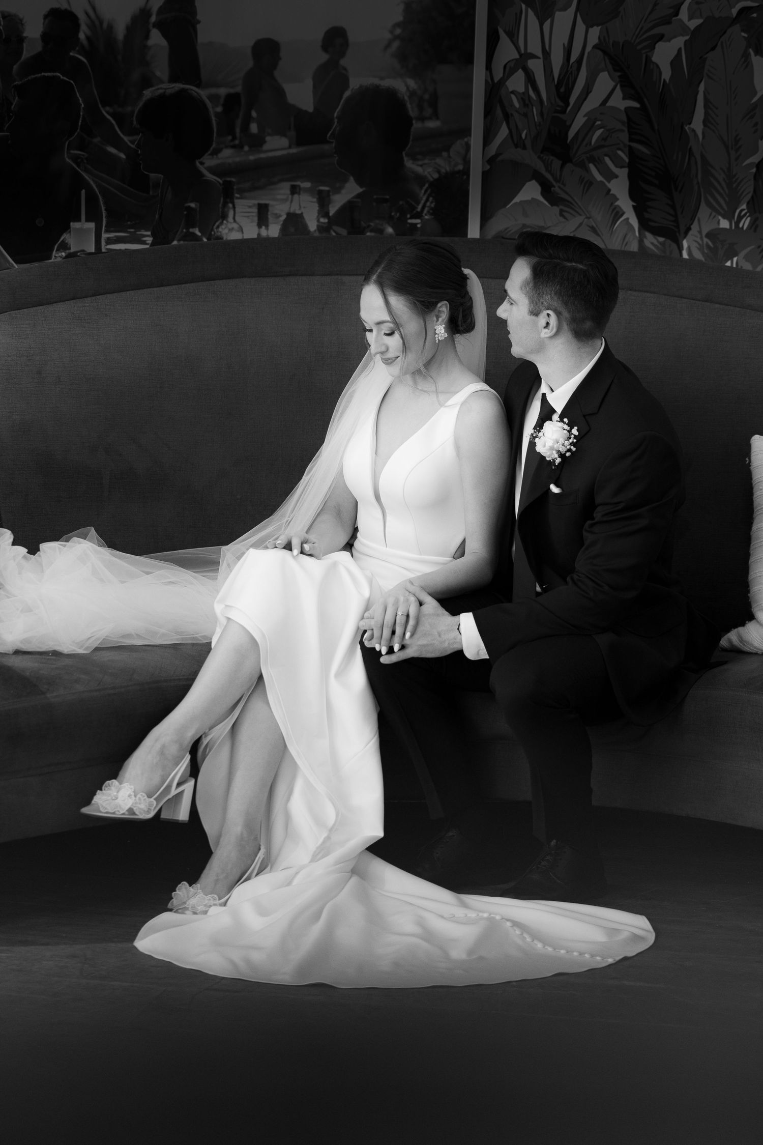 A black and white photo sequence shows a couple in wedding attire sitting together on a couch during a reception.