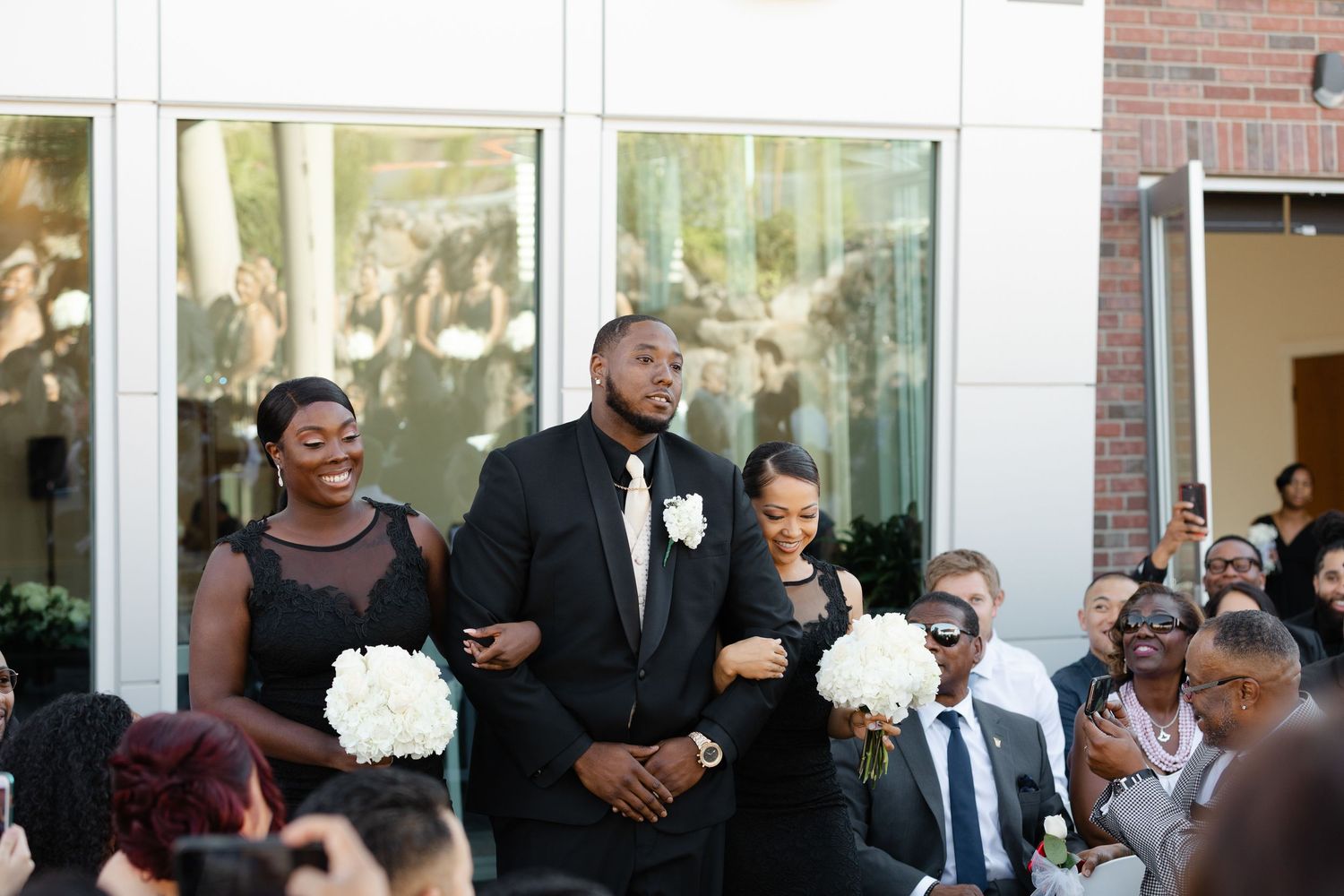 Wedding guests enjoy a festive reception celebration with dancing and mingling in an indoor venue.