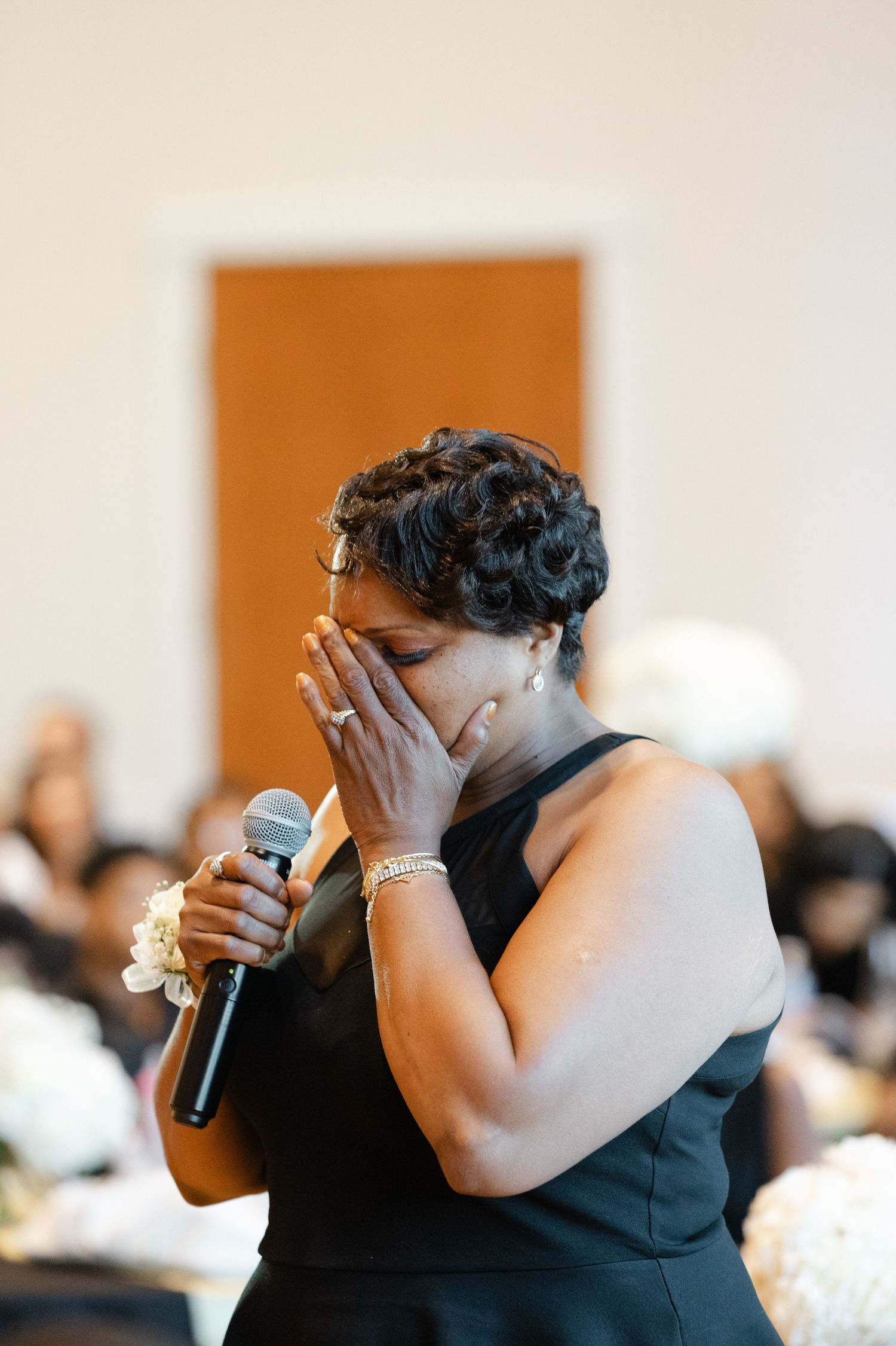 A person in a black sleeveless dress shows emotional reactions in a sequence of four similar photos at an event.