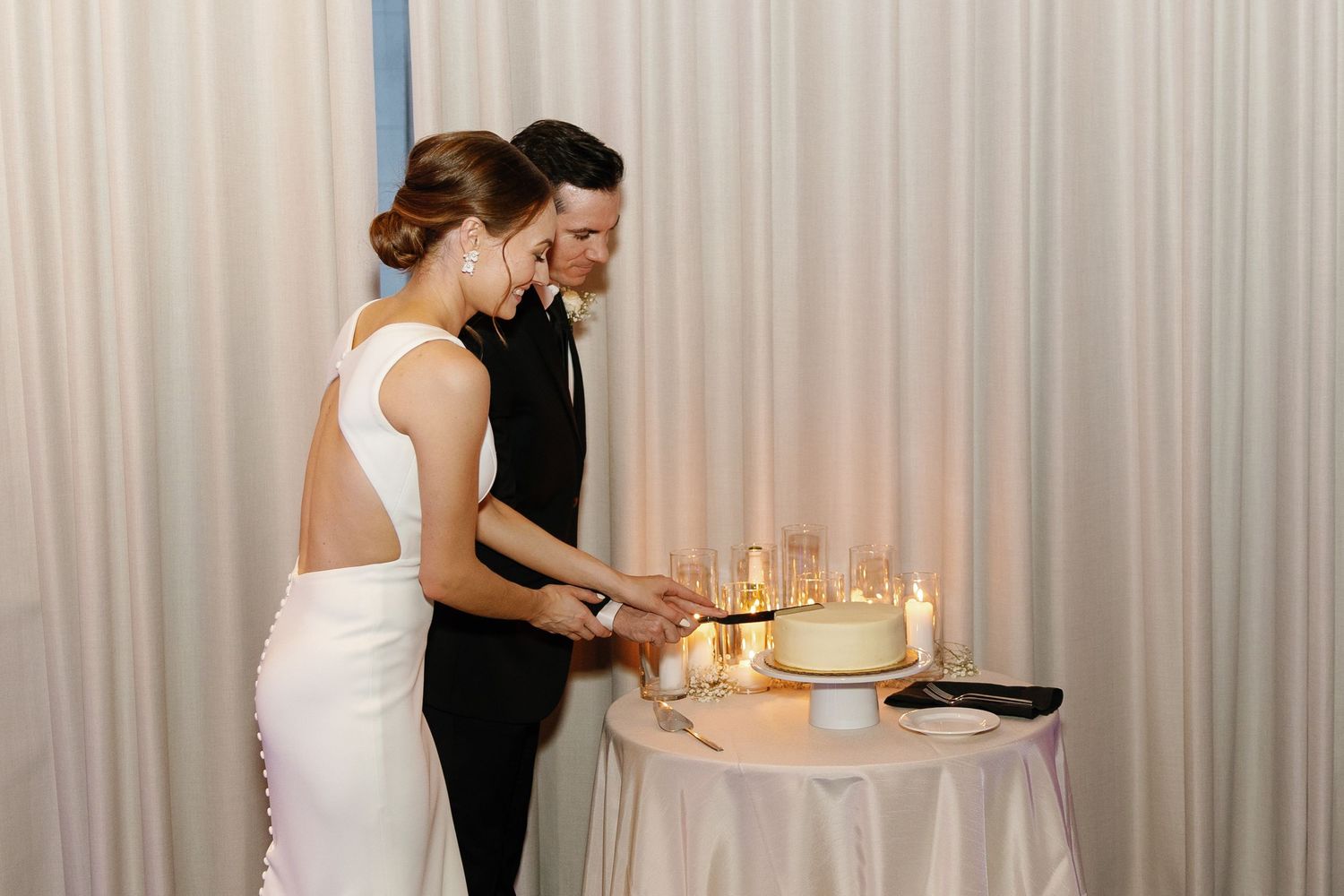 A wedding couple shares an intimate dance moment surrounded by candlelight at their reception.