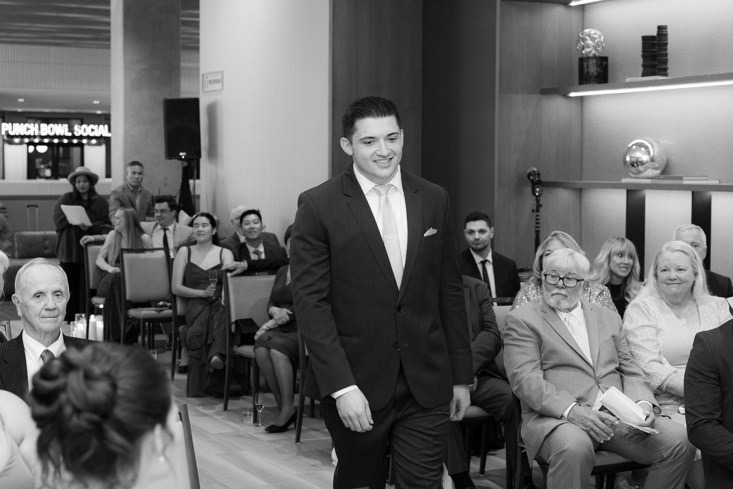 Black and white photo collage showing candid moments and reactions of wedding guests during a celebration.