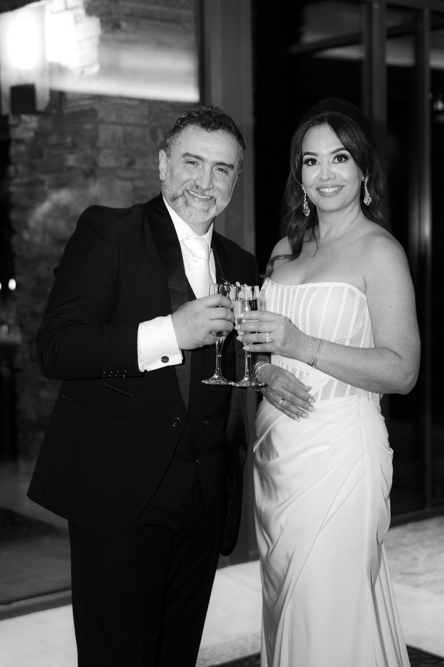 A couple in formal wedding attire share a toast together during their celebration.