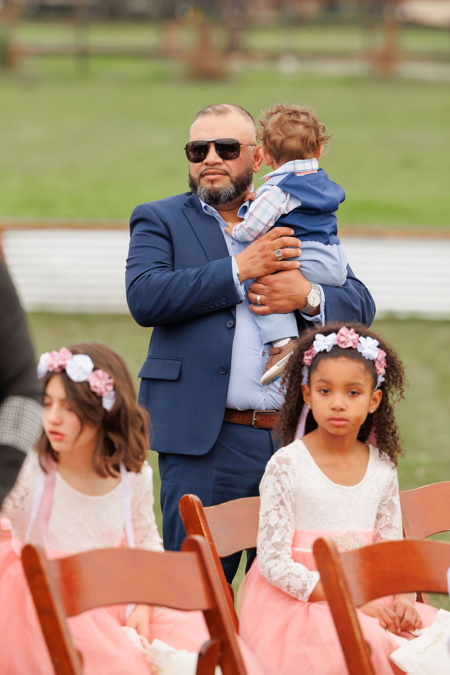 A series of photos showing a wedding ceremony with a person in a navy suit hugging someone while young girls in white dresses sit nearby.