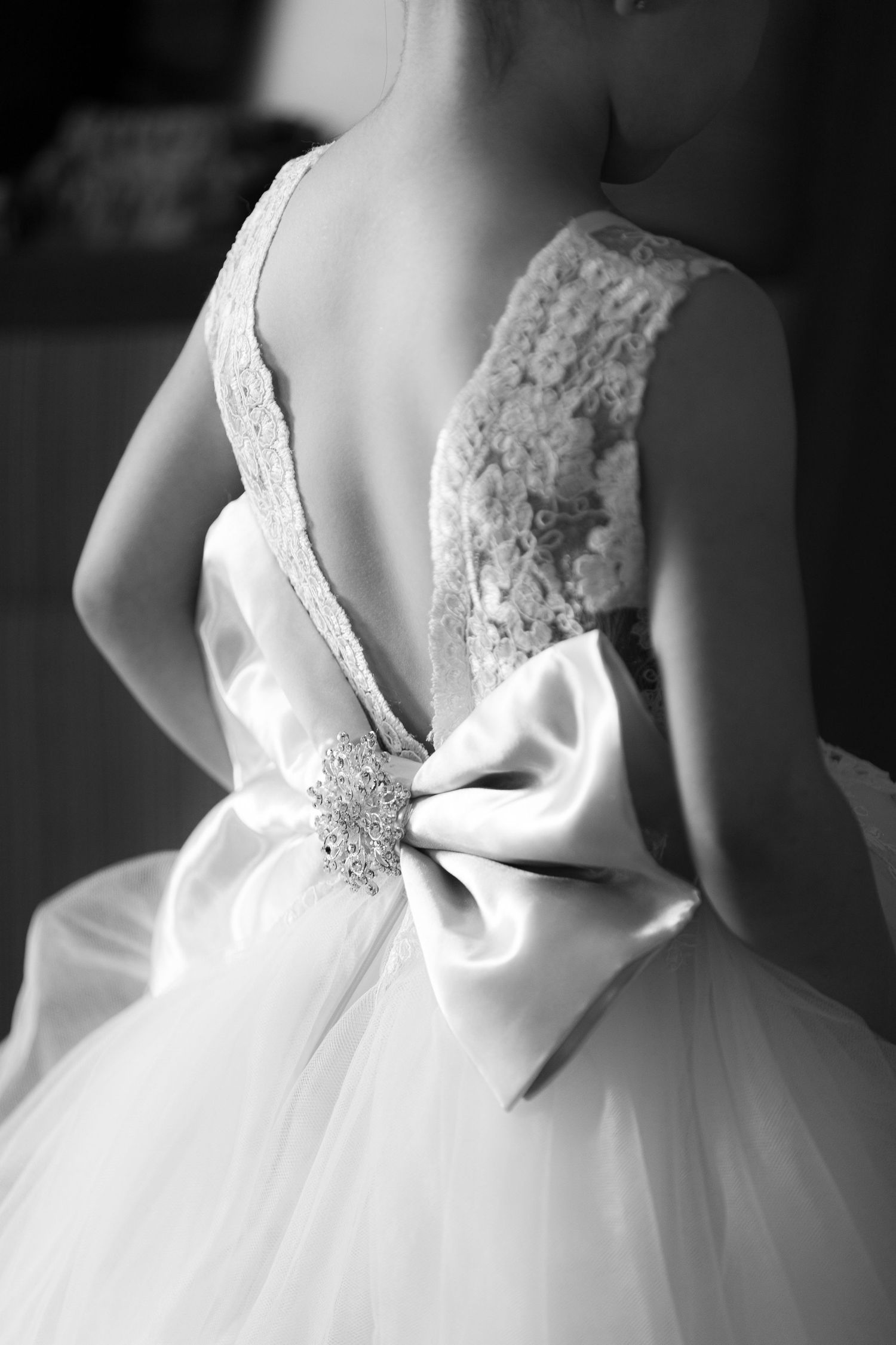Close-up details of a white wedding dress showing lace and beaded embellishments in black and white.