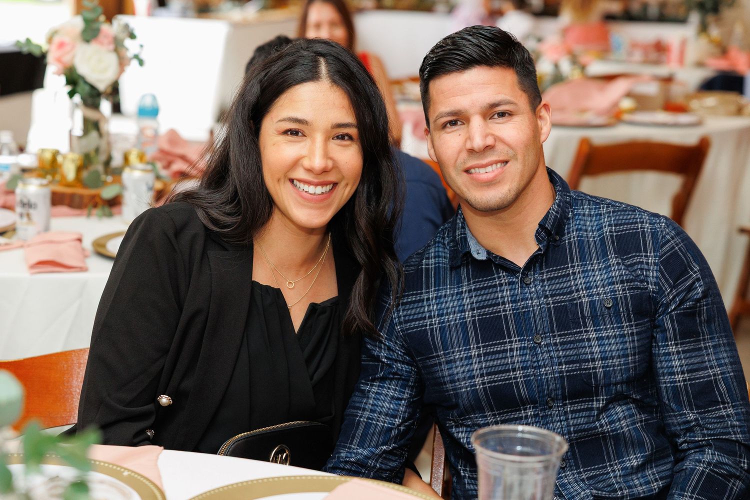A couple sits together at a restaurant table decorated with orange and white table settings.