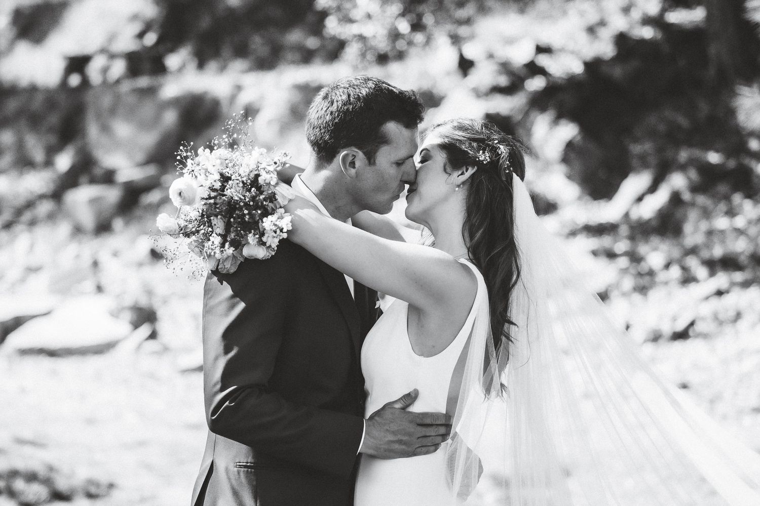 A romantic black and white photo series showing a couple kissing in various outdoor settings.