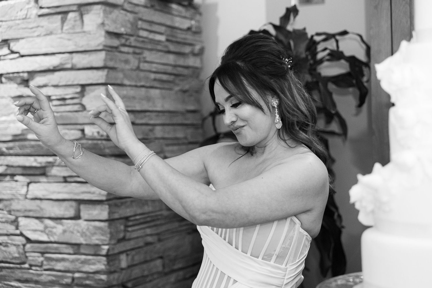 Black and white wedding photos showing romantic moments between newlyweds against a stone wall background.