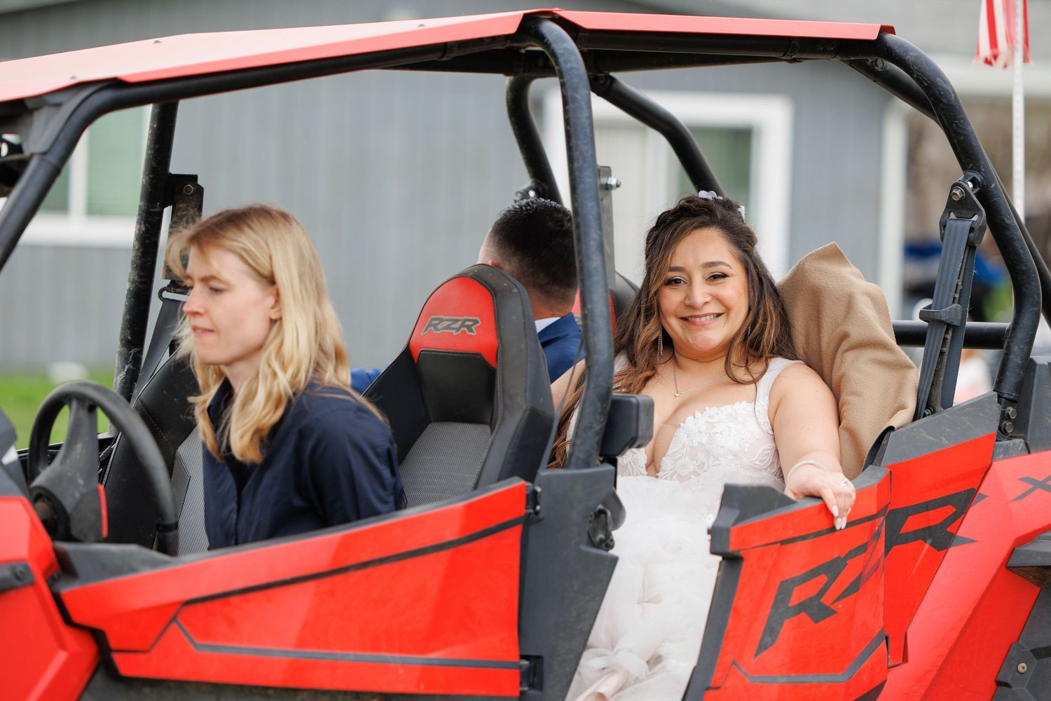 A series of people test driving a bright red sports car at a dealership or event.