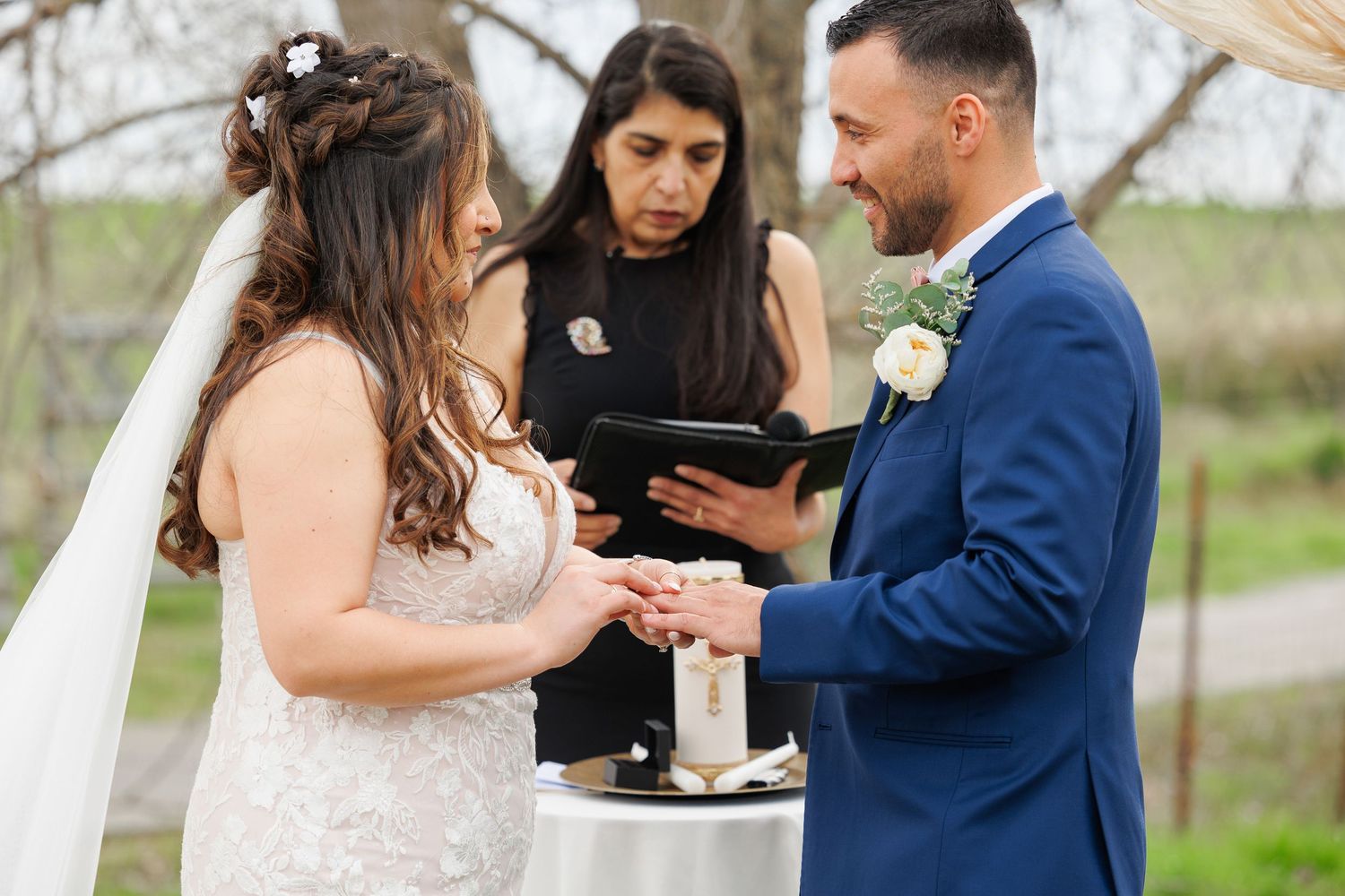 A couple shares an intimate moment during an outdoor wedding ceremony in front of guests.