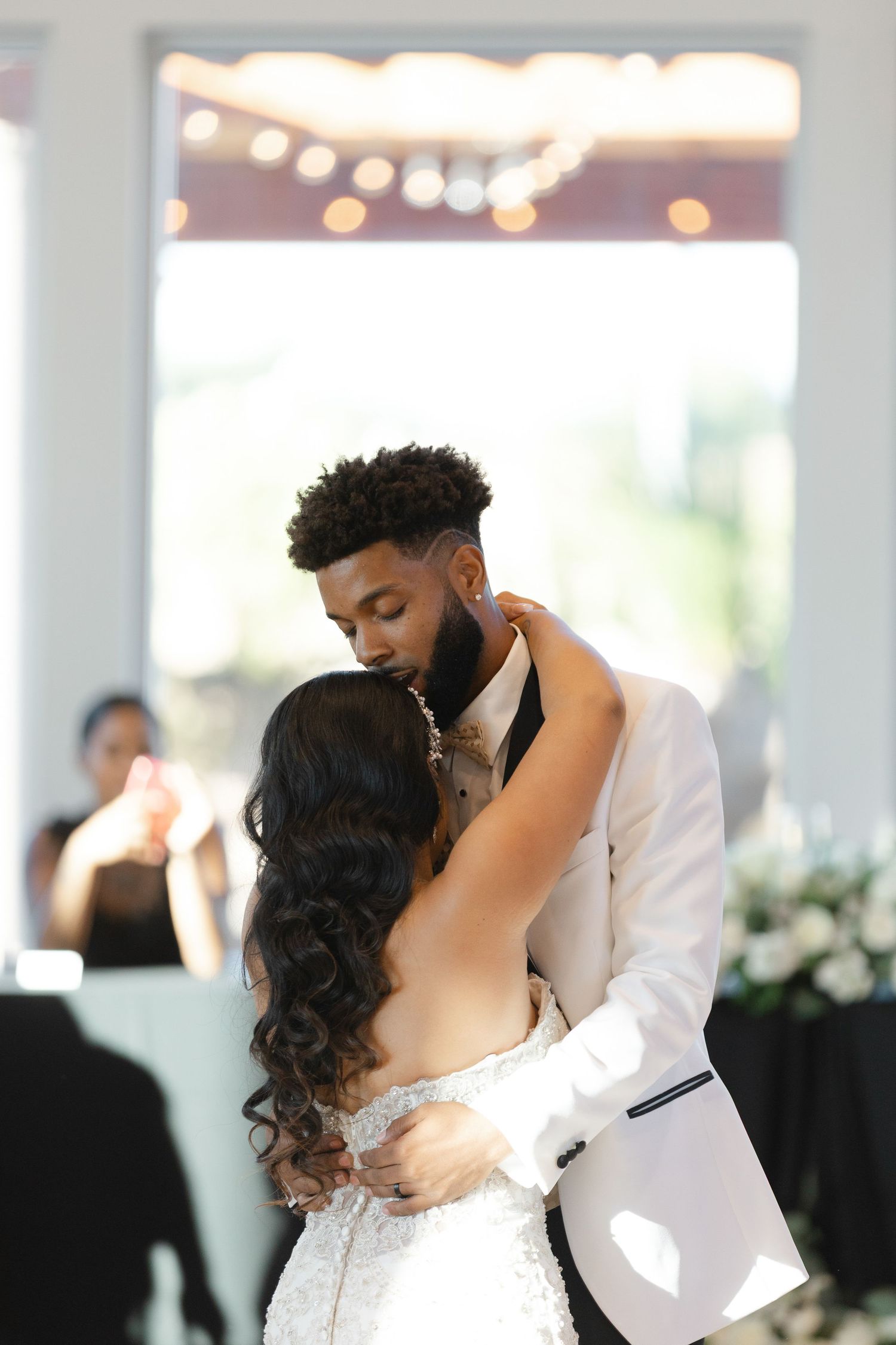 A romantic first dance between newlyweds at their wedding reception with soft lighting and elegant decor.