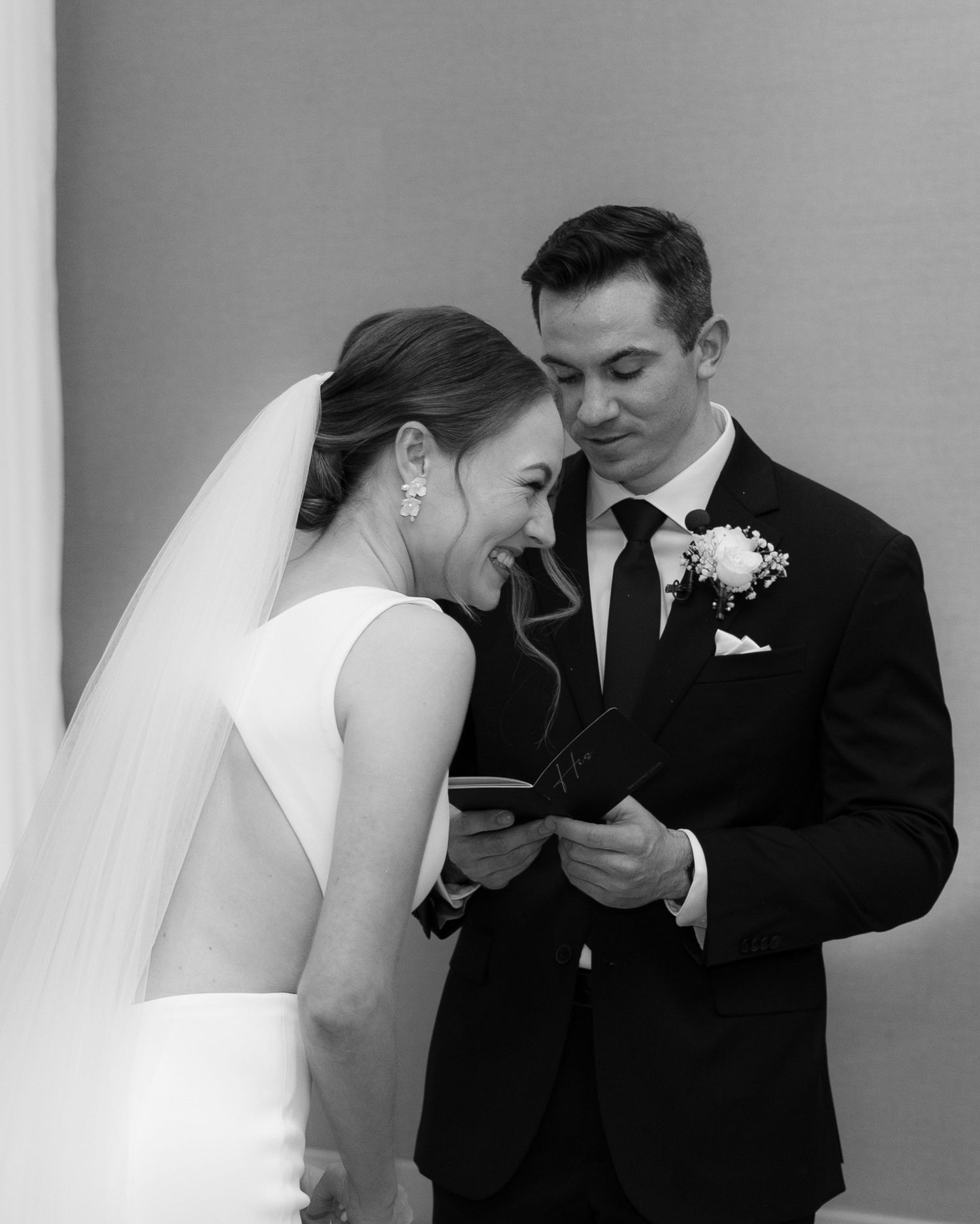 A black and white wedding photo series showing intimate moments between a bride and groom along a wall.