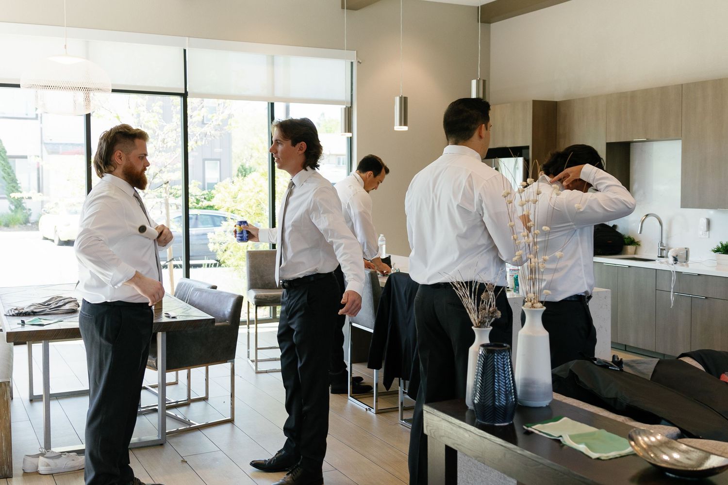 Restaurant staff in white shirts and black pants work together in a modern kitchen space during prep time.