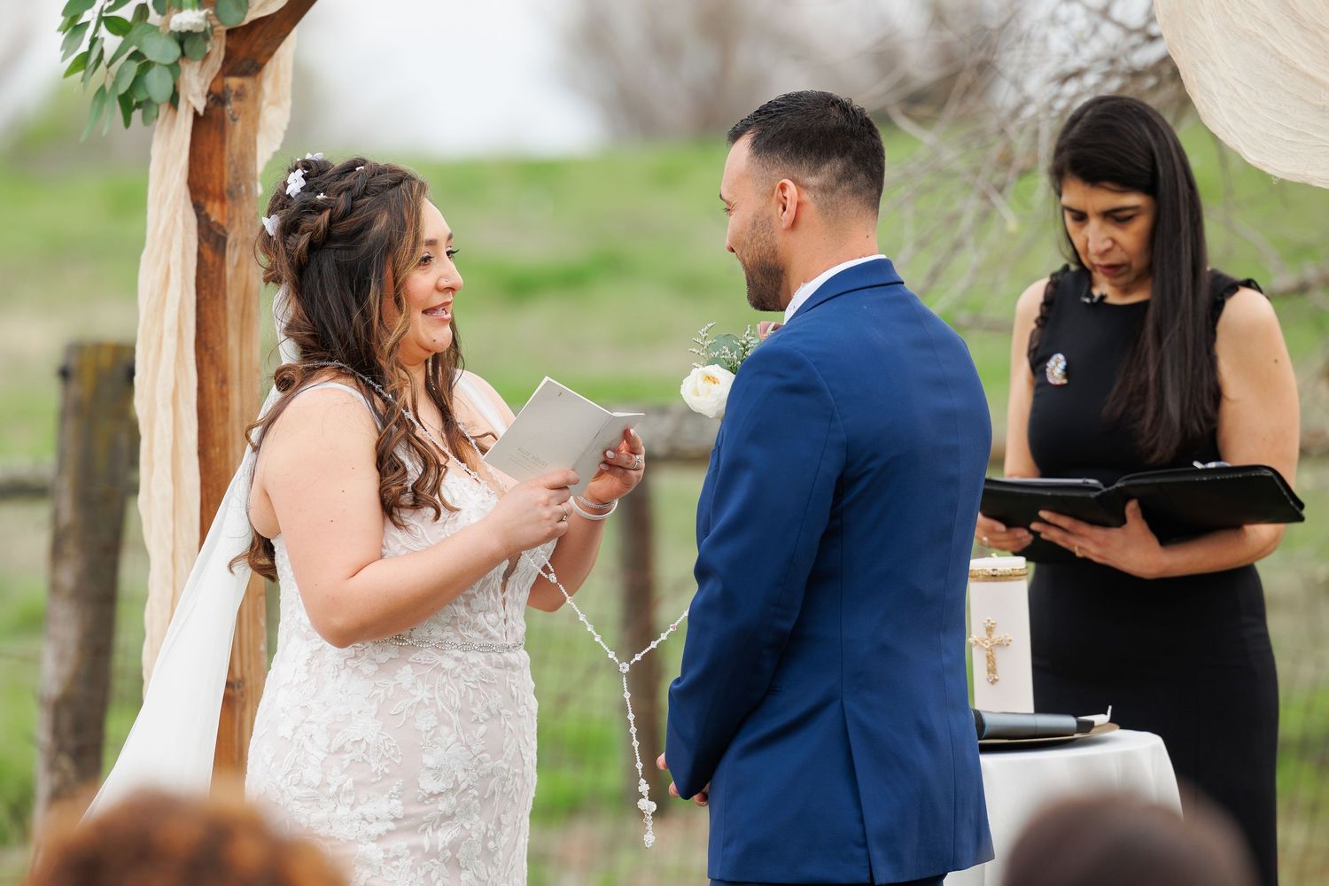A couple shares their first dance together at an outdoor wedding ceremony while guests look on.