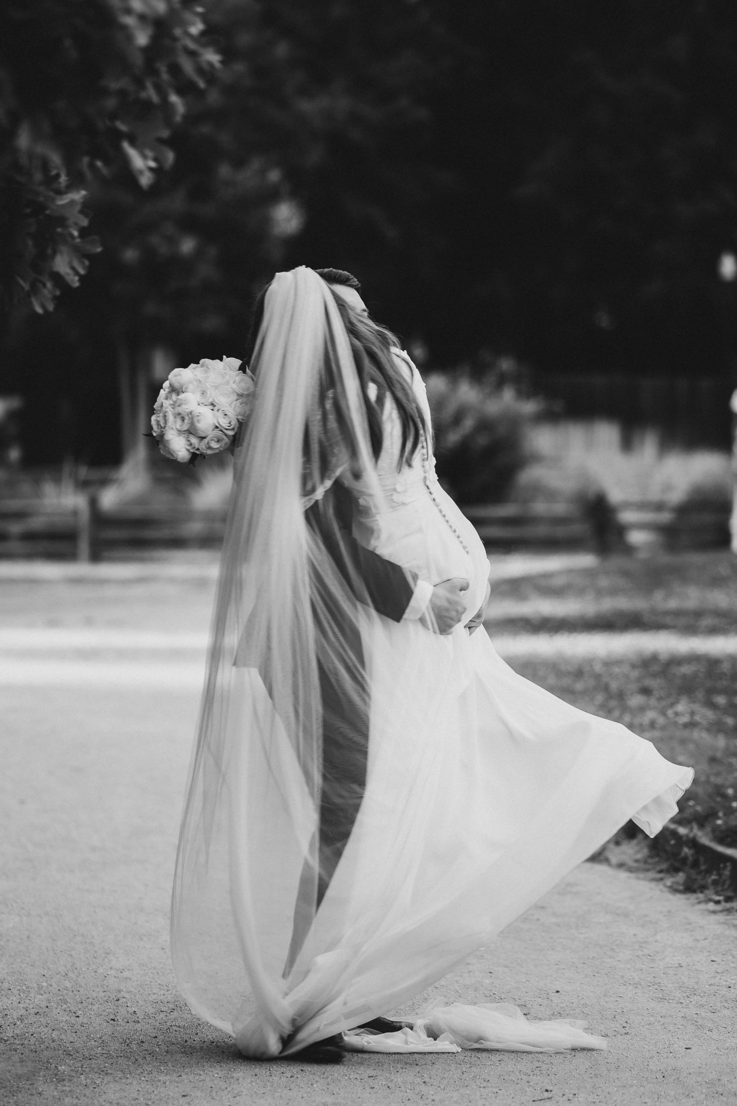 Black and white wedding photo showing flowing dress and veil movement during dance.