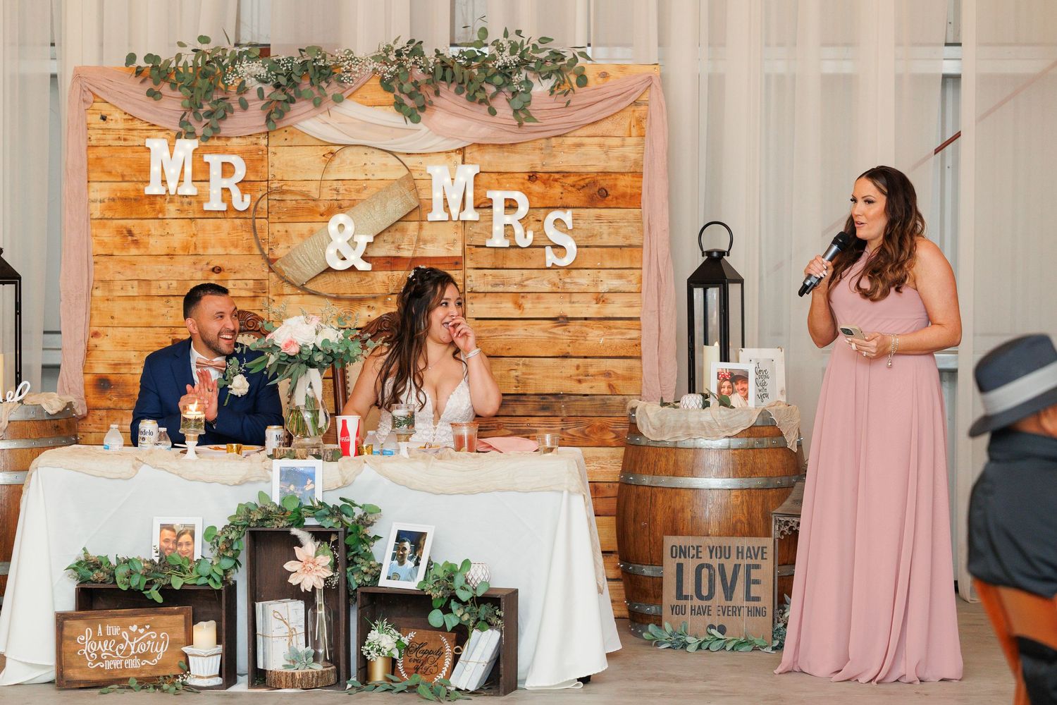 A rustic wedding reception venue with wooden walls, lanterns, and pink bridesmaid dresses visible in multiple photos.