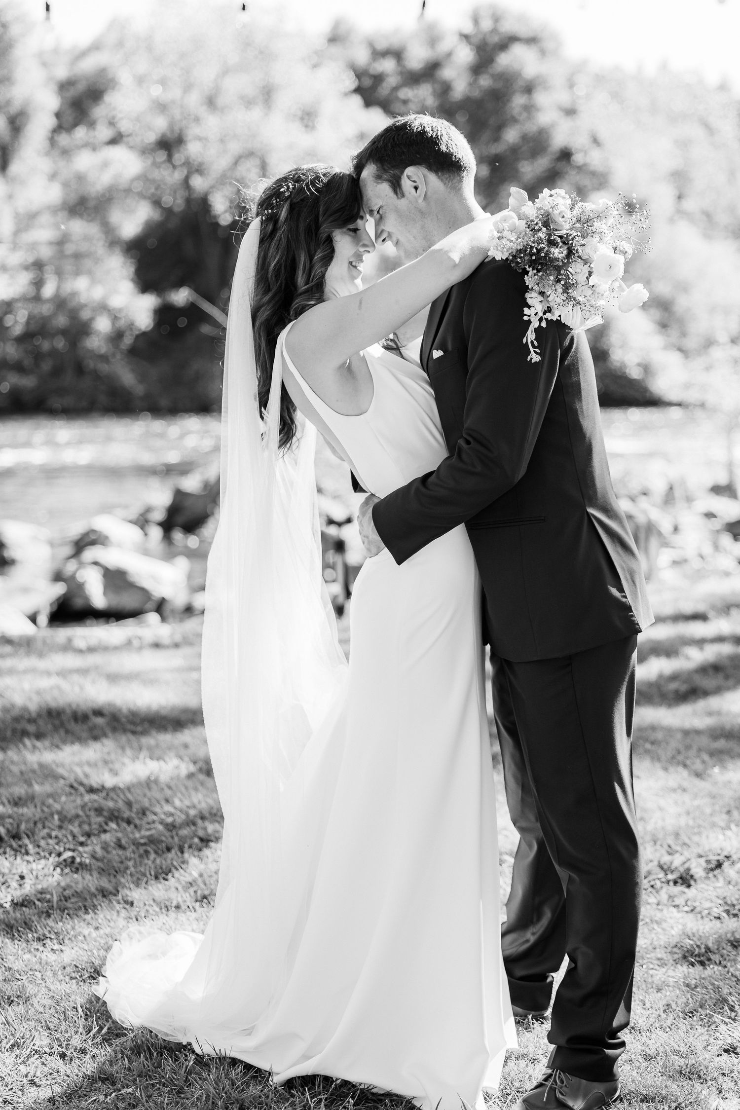A romantic black and white wedding photo series showing a couple dancing and embracing outdoors in formal attire.