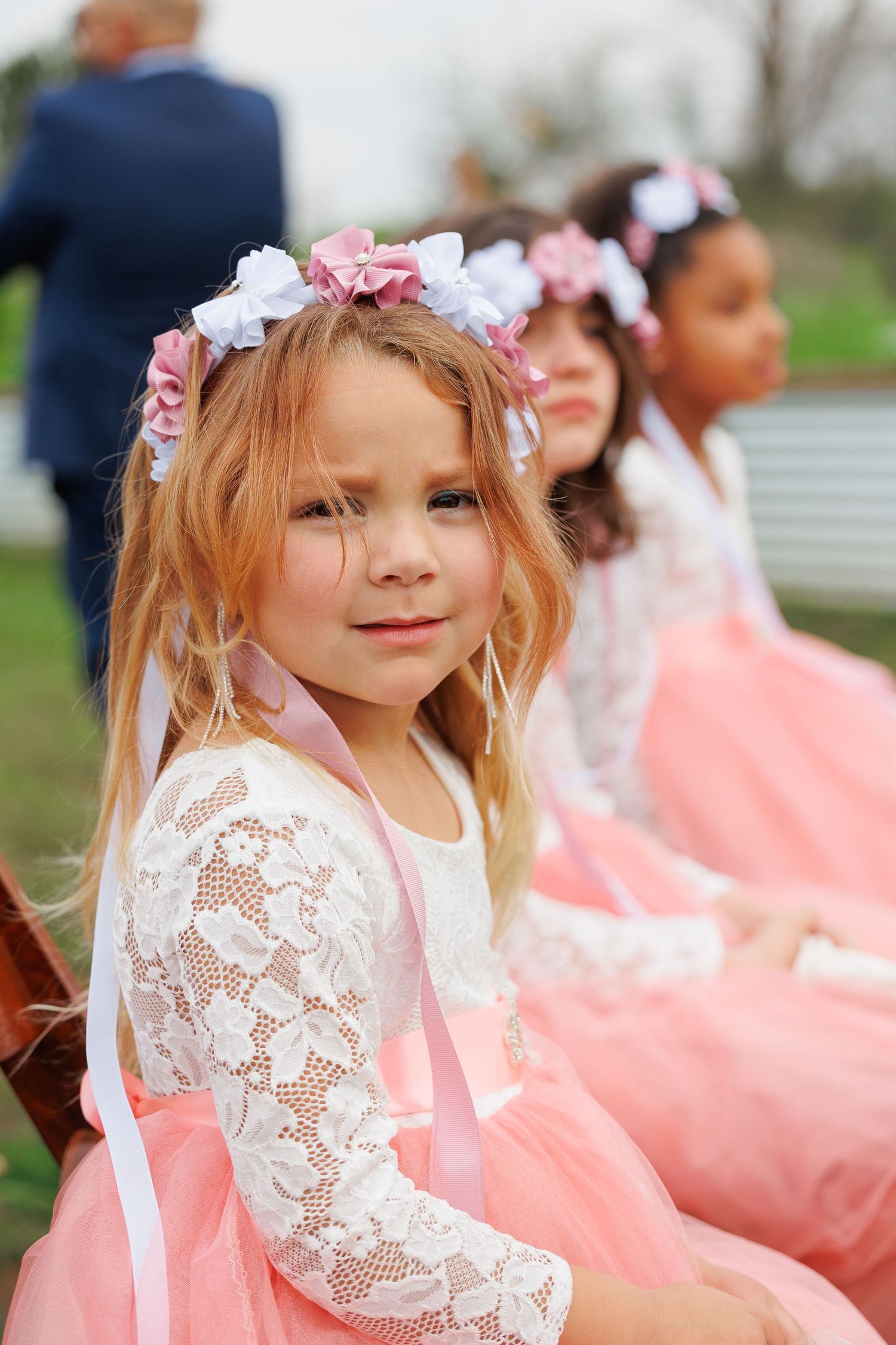 Young dancers in pink tulle dresses and floral headpieces pose during a performance or recital.