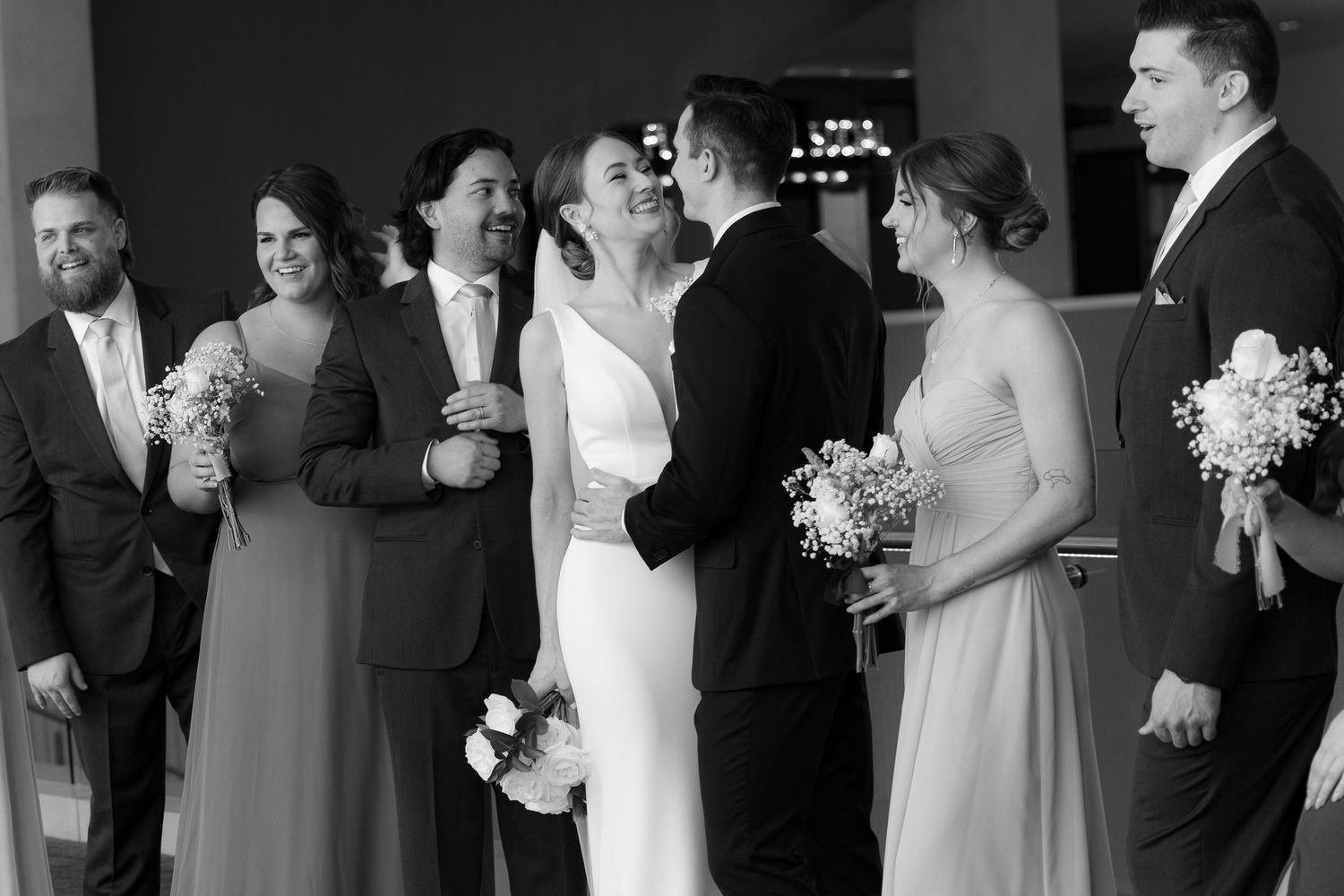 A black and white wedding photo montage showing candid moments of couples and guests at a celebration.