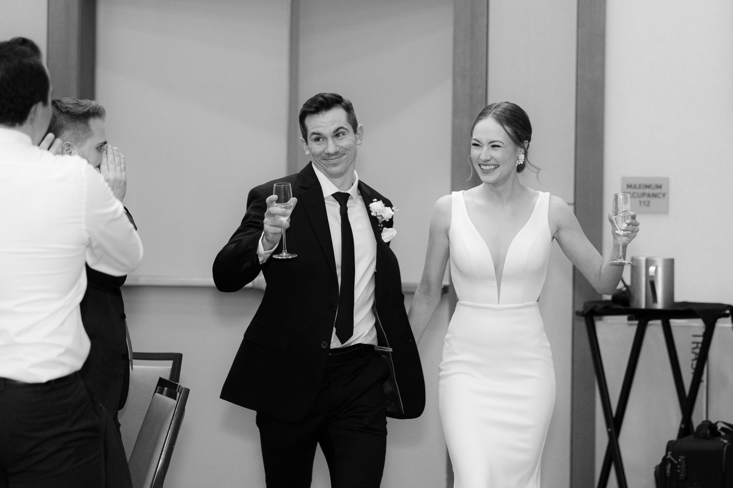 A series of black and white wedding photos showing candid moments between couples and guests at a celebration.