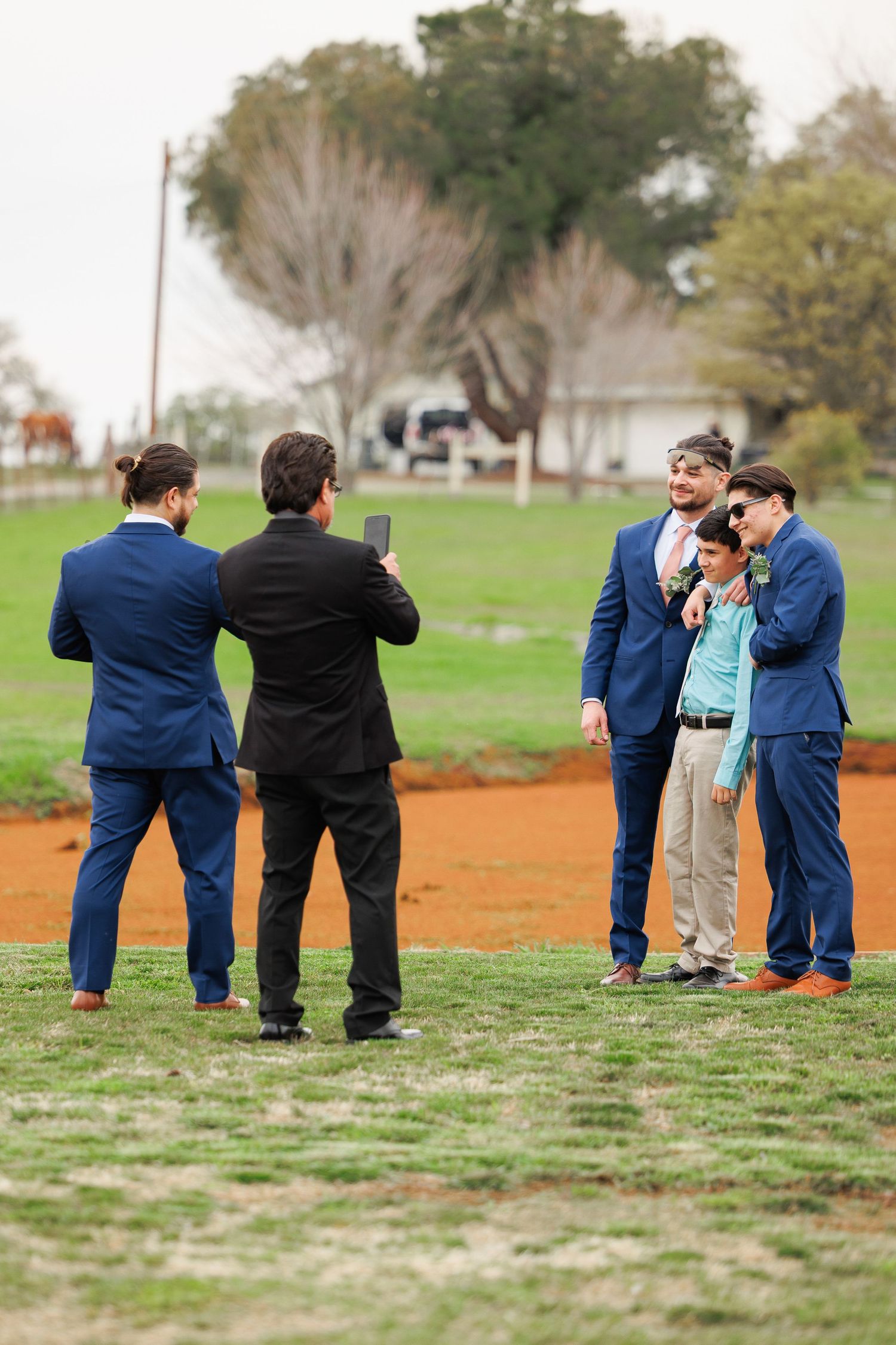 A sequence of candid outdoor photos showing people in formal attire interacting on a grassy field.