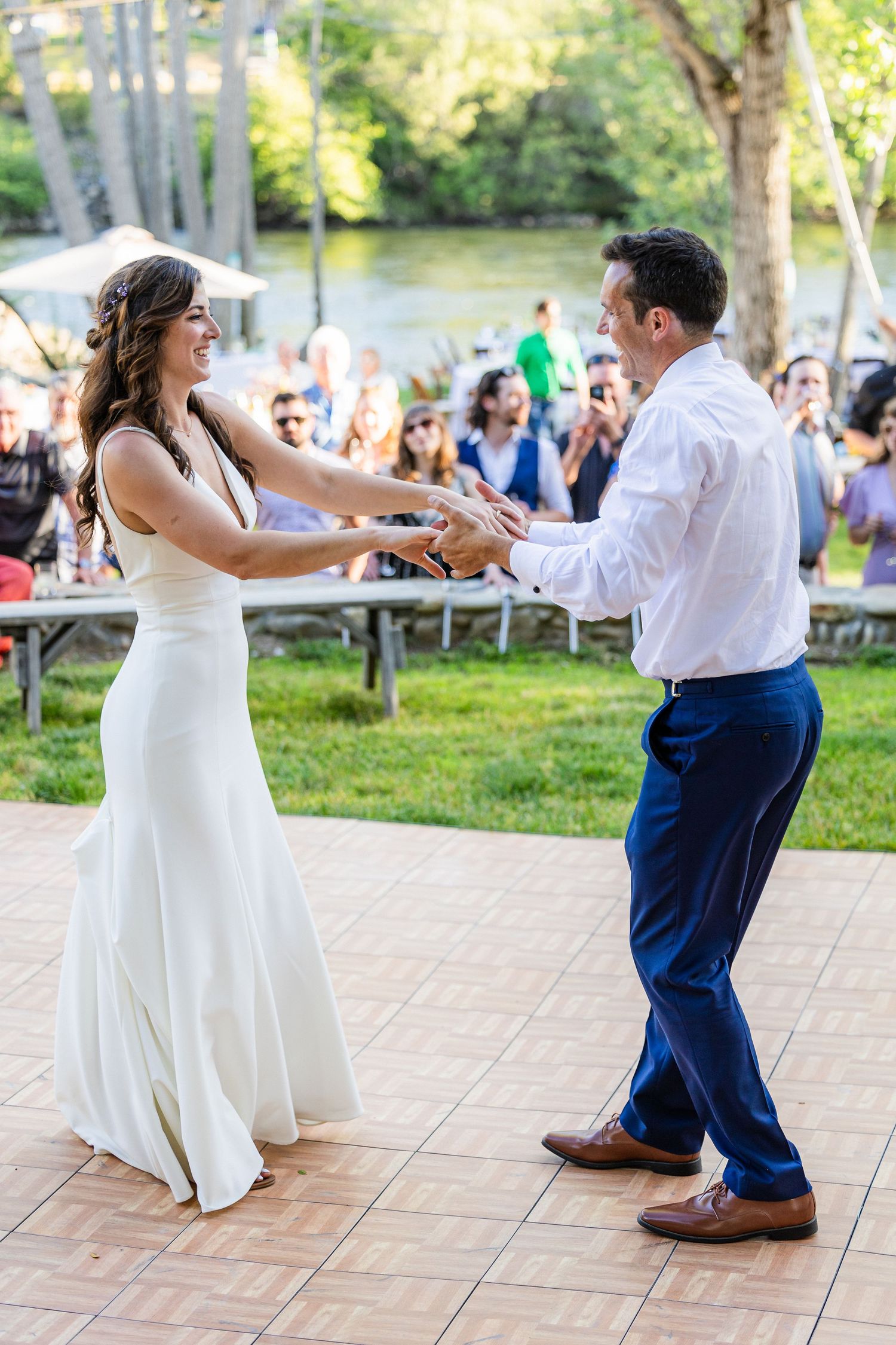 A couple dancing together on an outdoor patio during what appears to be a wedding celebration.