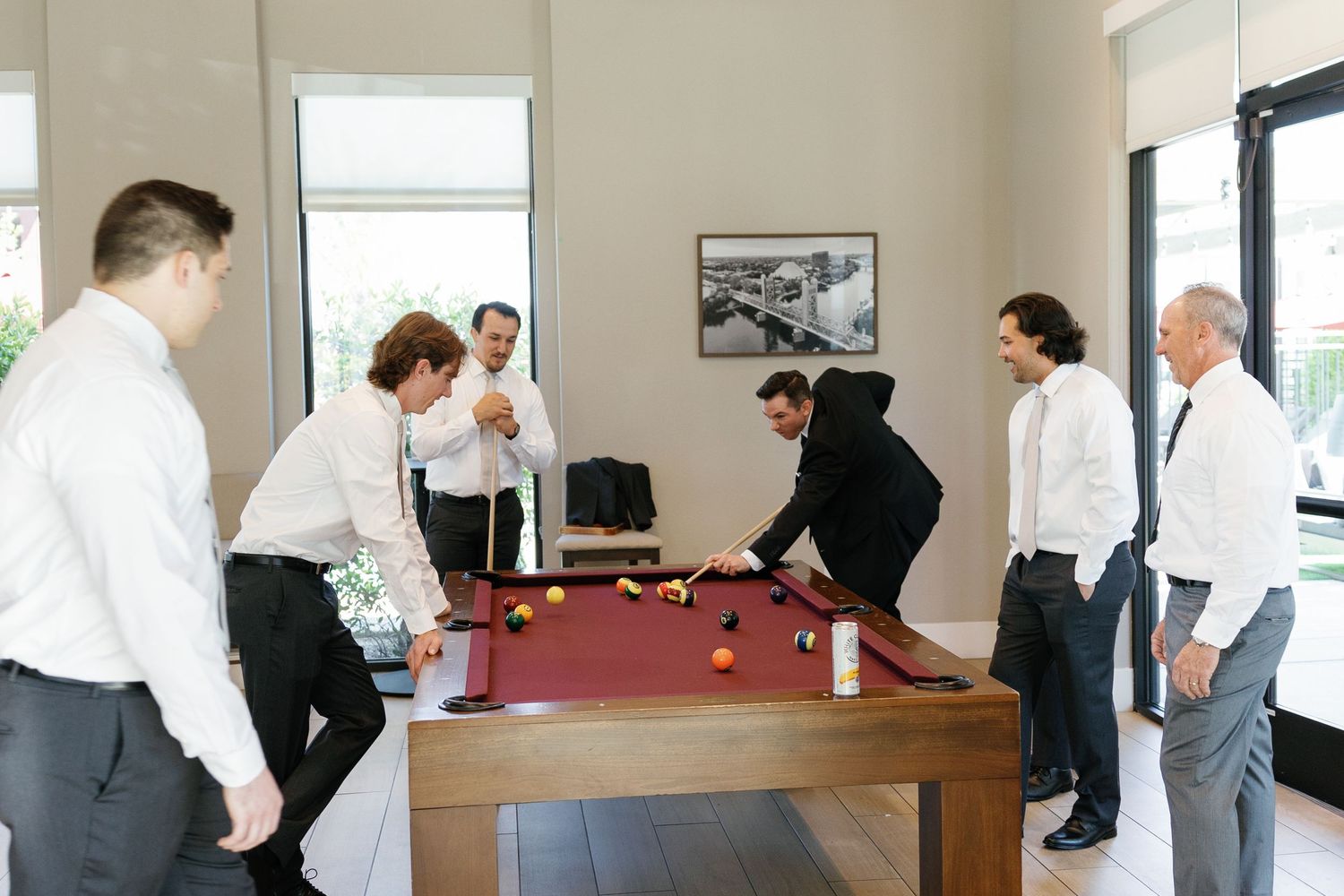 People gathered around a pool table in a casual indoor setting during a social event.