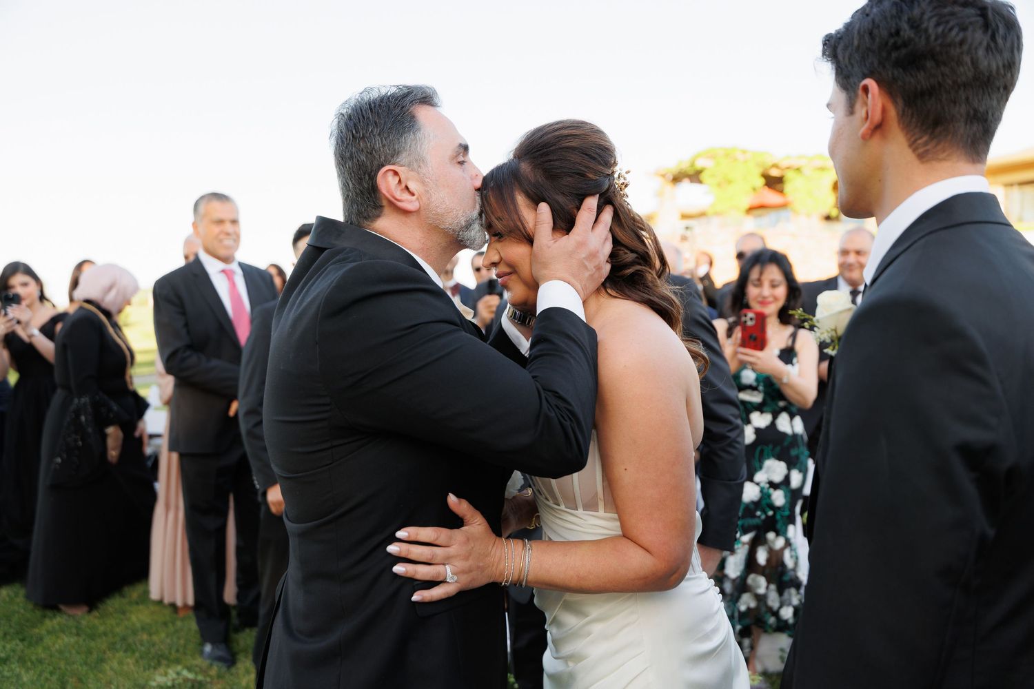 A series of romantic wedding photos showing couples embracing and dancing at an outdoor reception celebration.