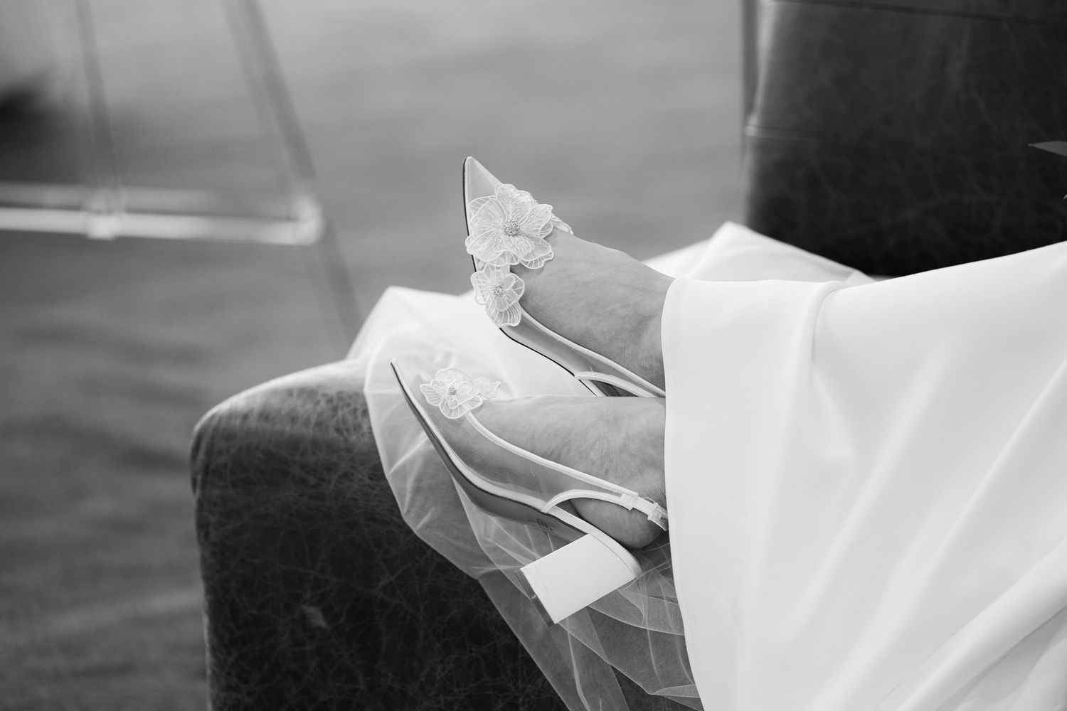 A black and white close-up photograph shows a hand delicately folding an origami paper crane.