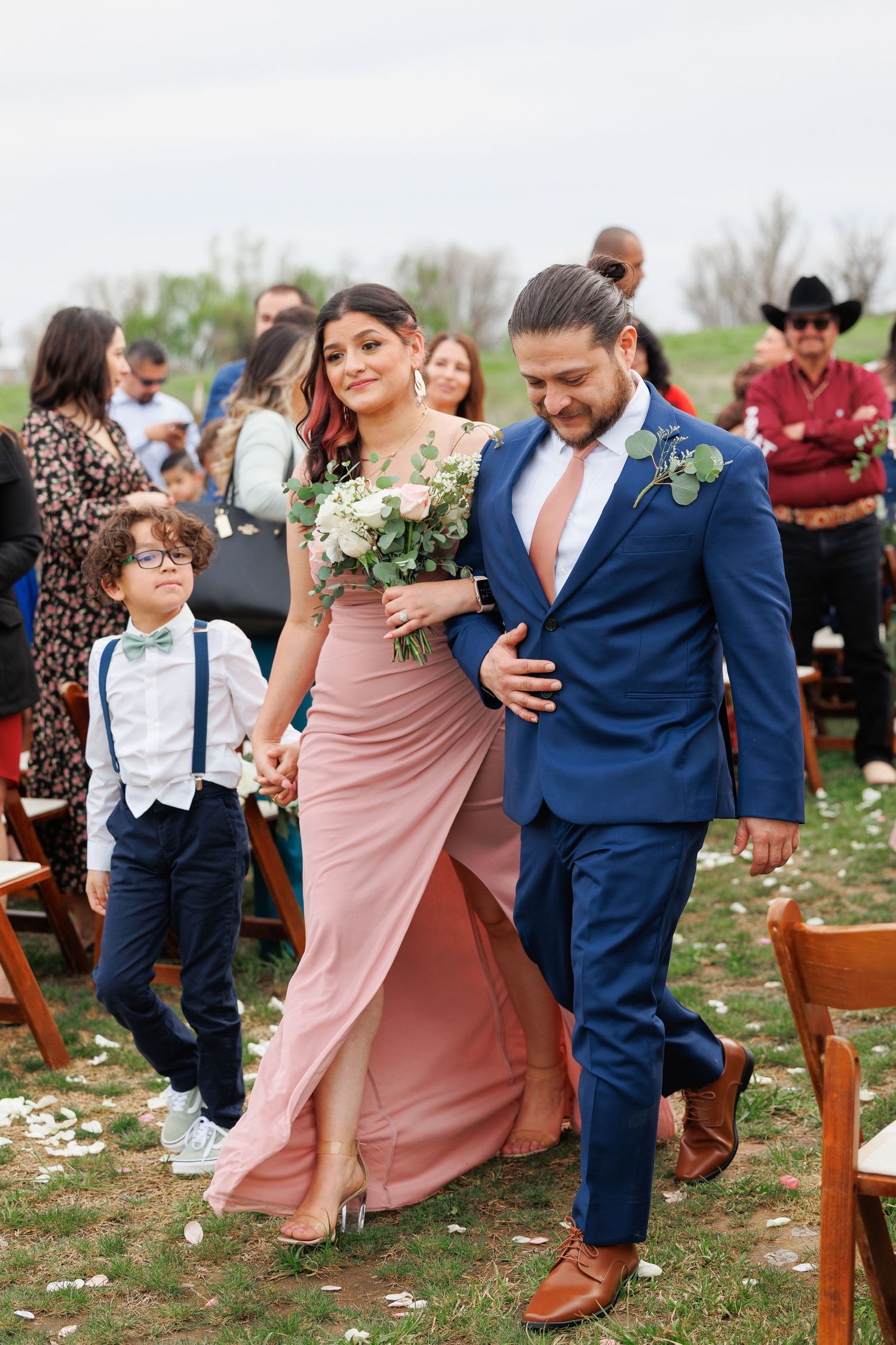 A sequence of wedding party photos showing playful dancing and movement in an outdoor garden setting.