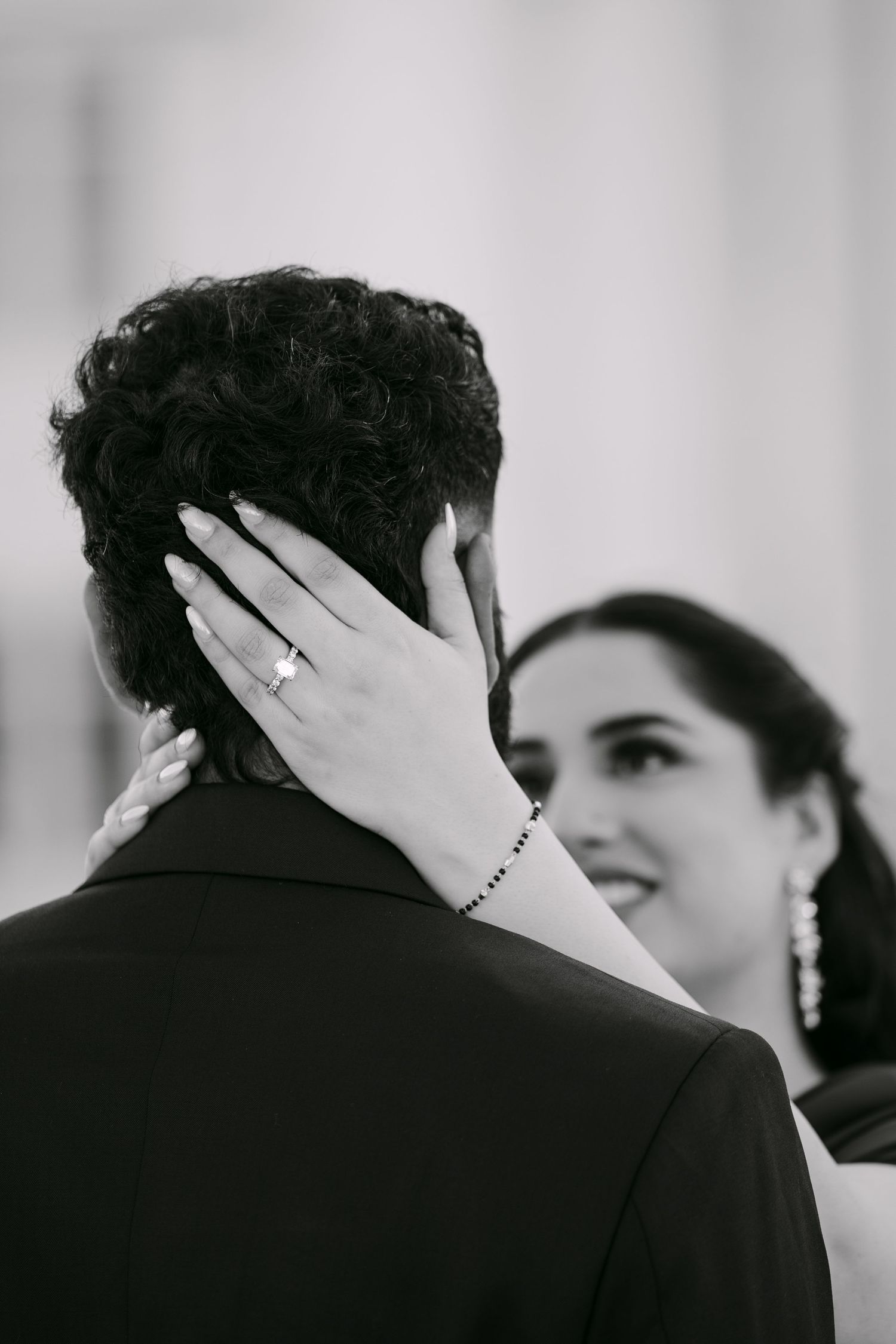 A romantic black and white photo sequence showing a tender kiss between a couple at a wedding.