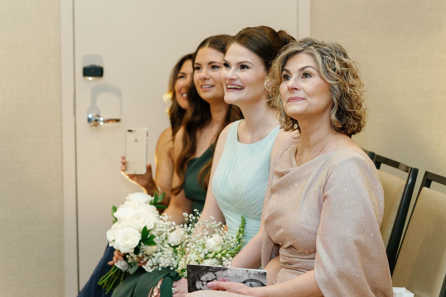 Wedding guests seated in formal attire watch intently during an emotional ceremony moment.