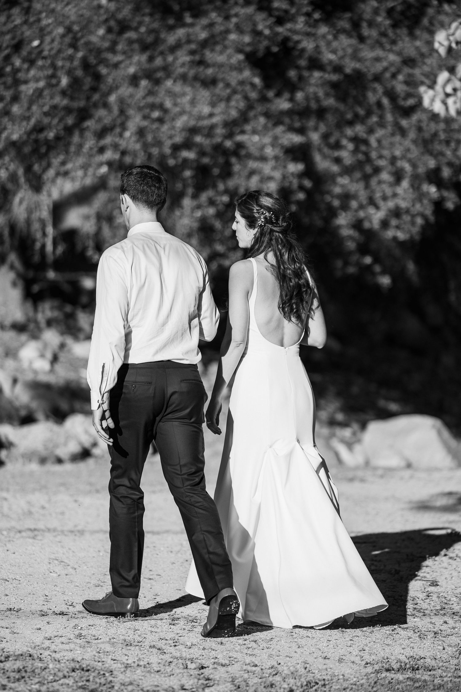 A black and white photo series showing a couple sitting together on the ground in formal wedding attire.
