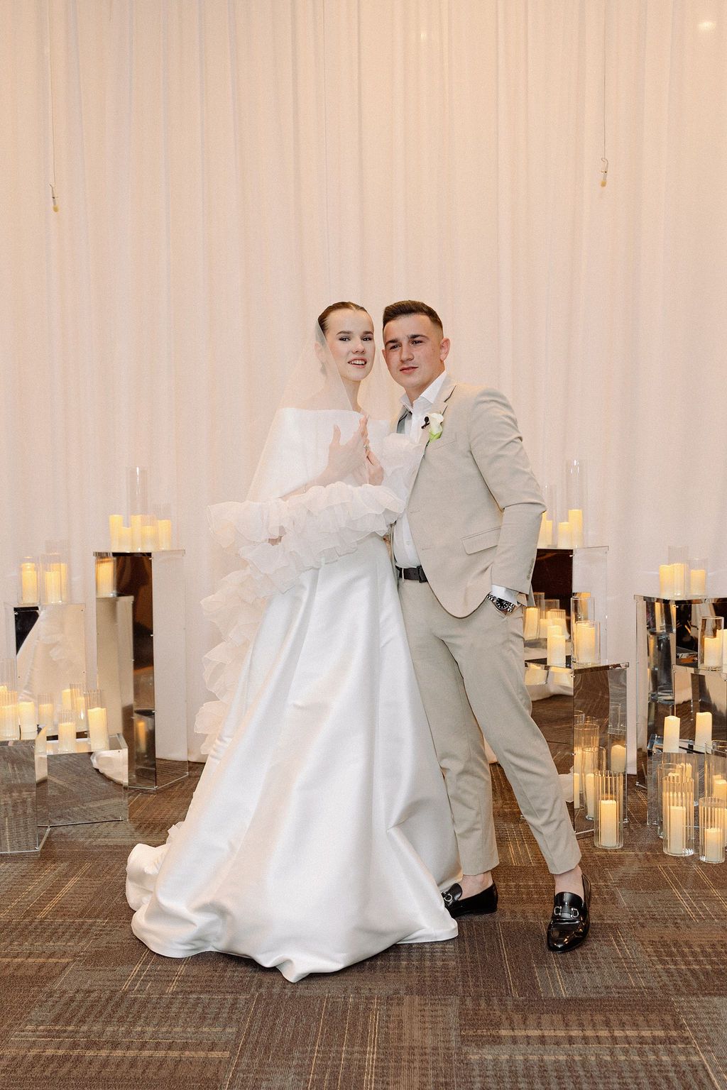 A series of playful wedding dance photos against a white backdrop with candlelit decor.