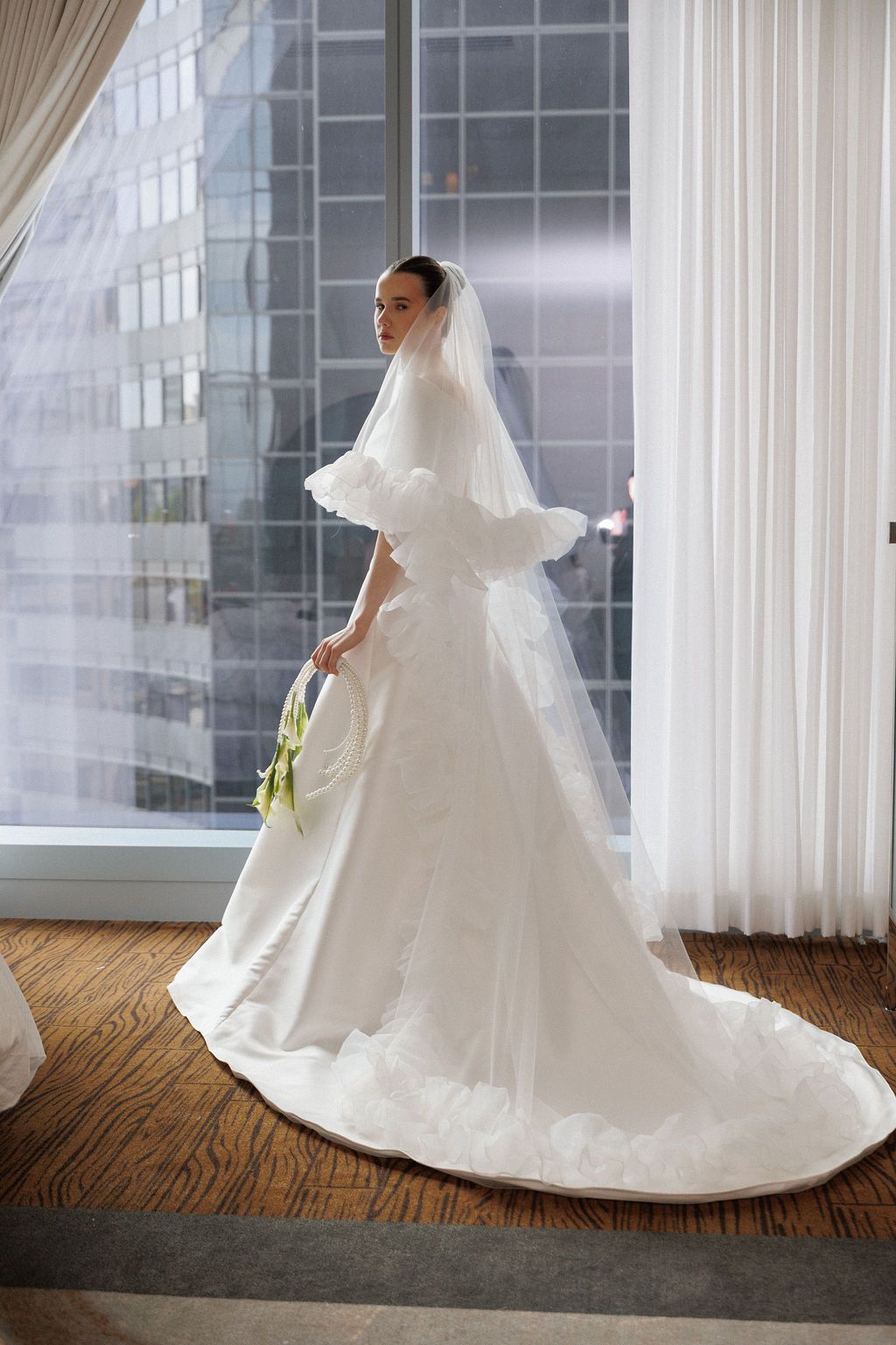 Elegant white wedding dress with a flowing train photographed in sequence against a bright window-lit room.