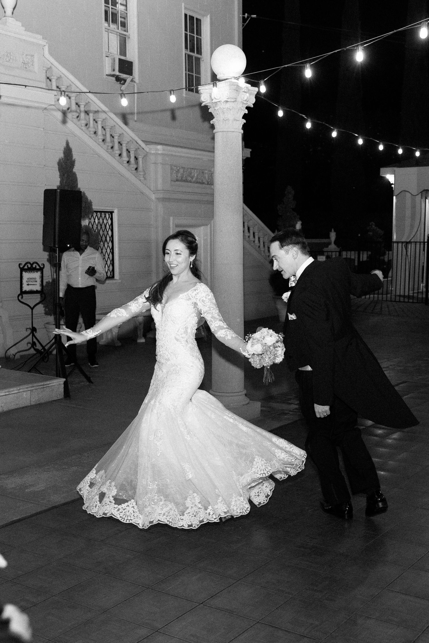 Black and white photos show a couple dancing together in formal attire under string lights at an outdoor venue.