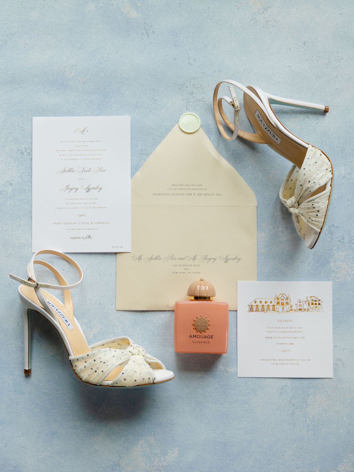Elegant wedding invitation suite with peach accents and bridal shoes arranged on light blue background.