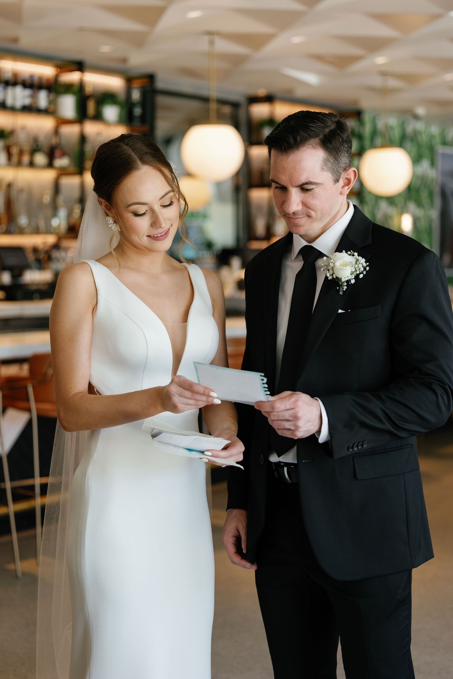 A bride and groom share an intimate moment reading letters to each other before their wedding ceremony.