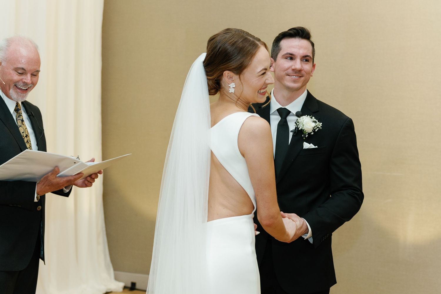 A wedding couple shares their first dance together in a ballroom while guests watch from the sides.