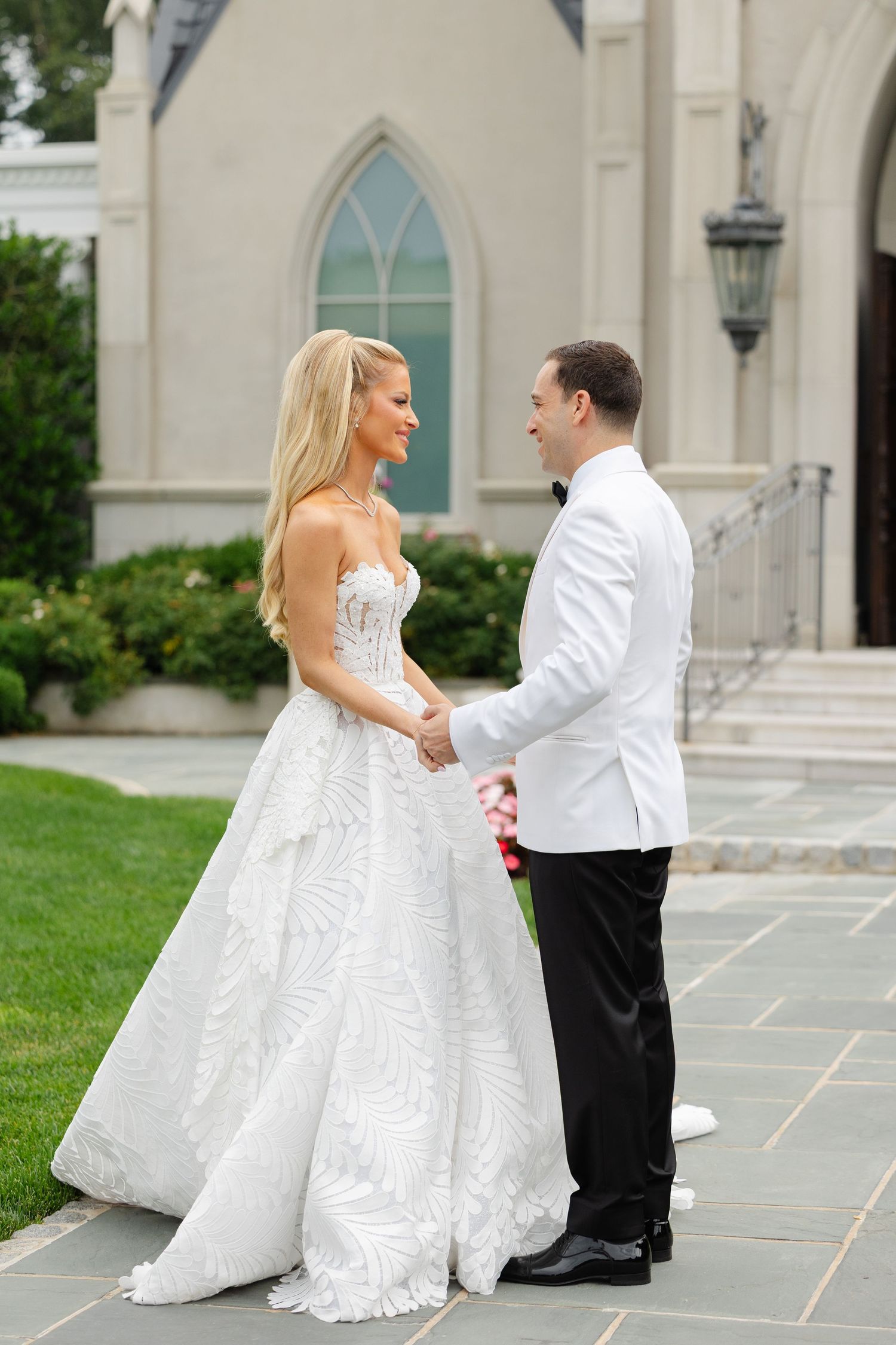 A romantic wedding photo series showing a couple in white formal attire posing on stone steps outside a church.