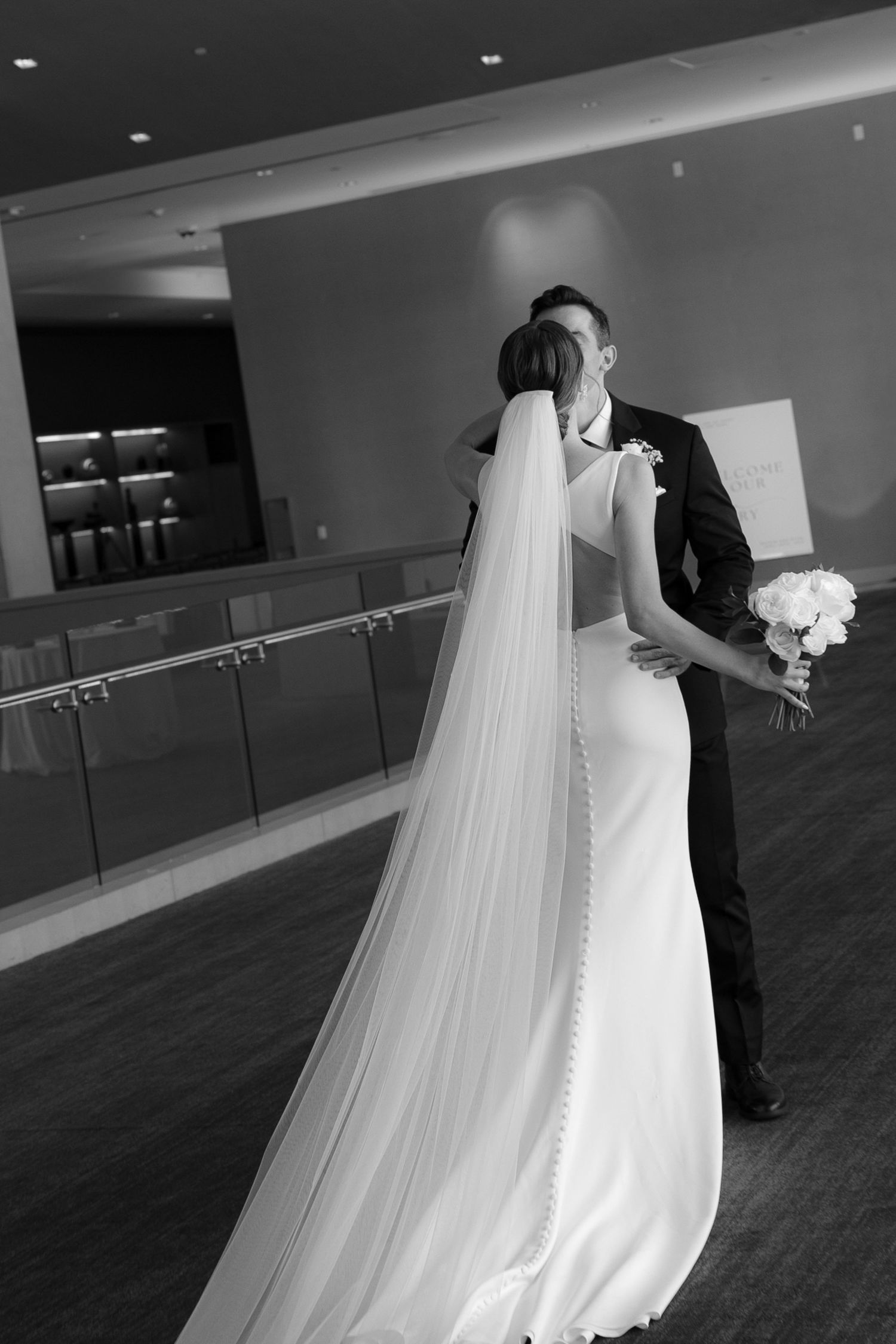 A flowing white wedding dress with a long veil is captured in a series of elegant black and white photographs.