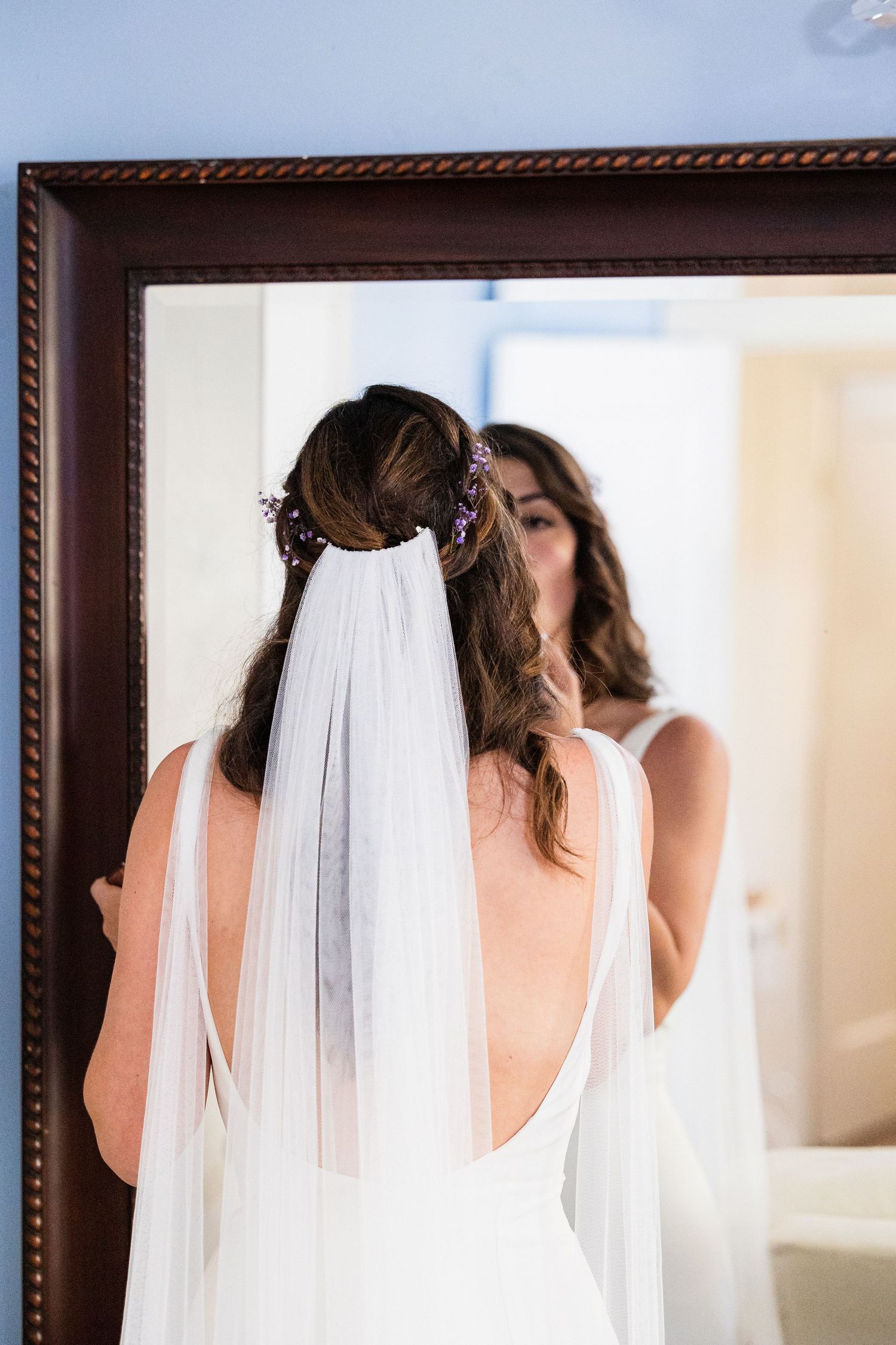 Bride in white wedding dress with flowing veil captured in a series of elegant back view portraits.