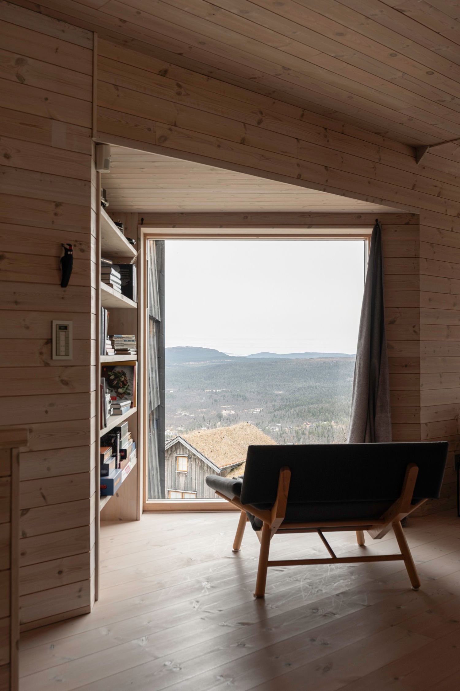 Fåtölj och fönster mot fjäll