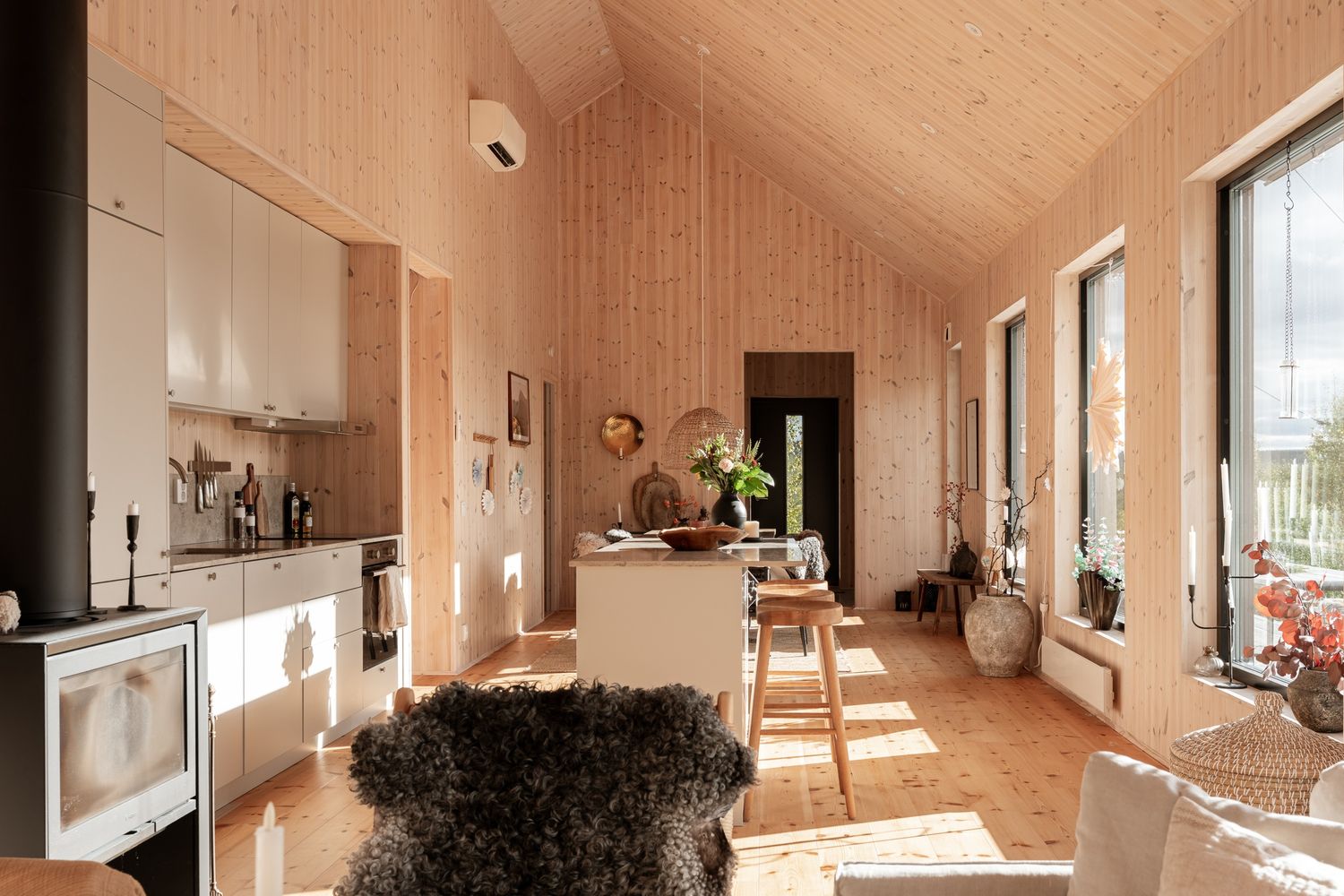 Kök med träpanel och stora fönster