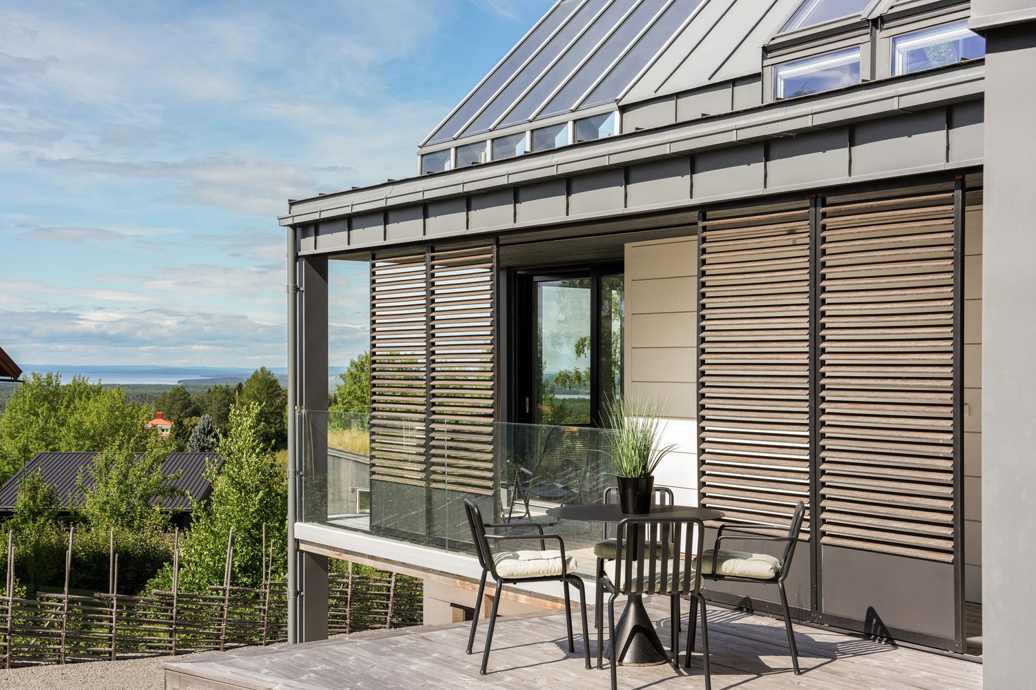 Terrass med lameller och glasräcke