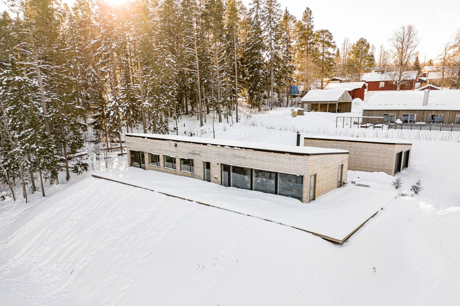 Hus och skog från luften i snö
