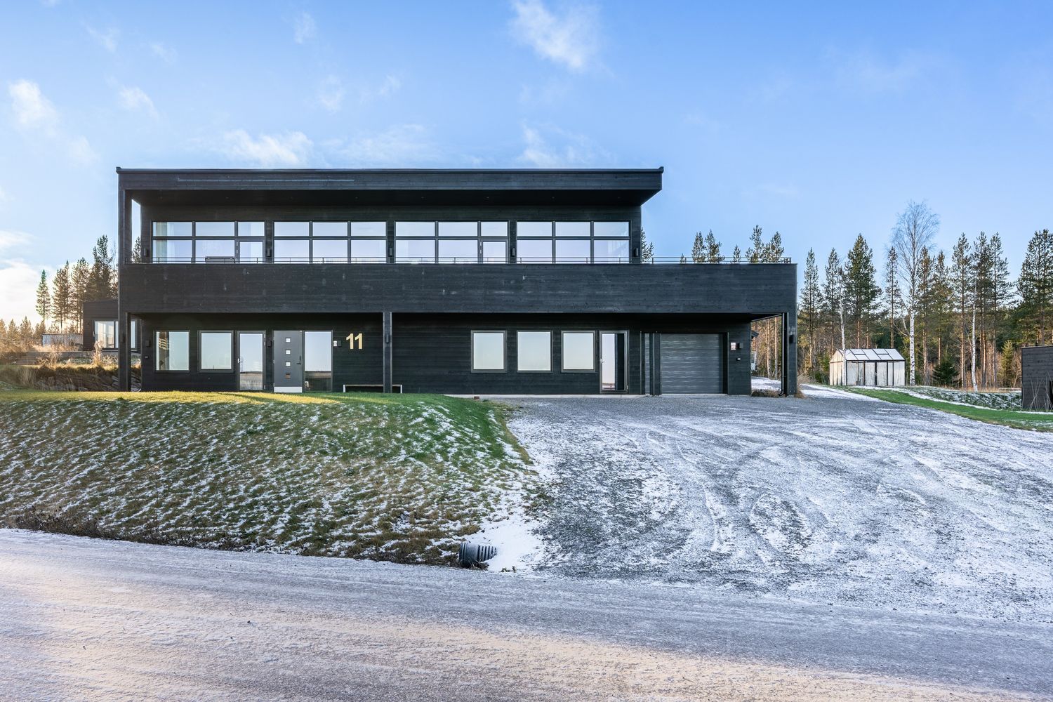 Mörk husfasad med stora glaspartier
