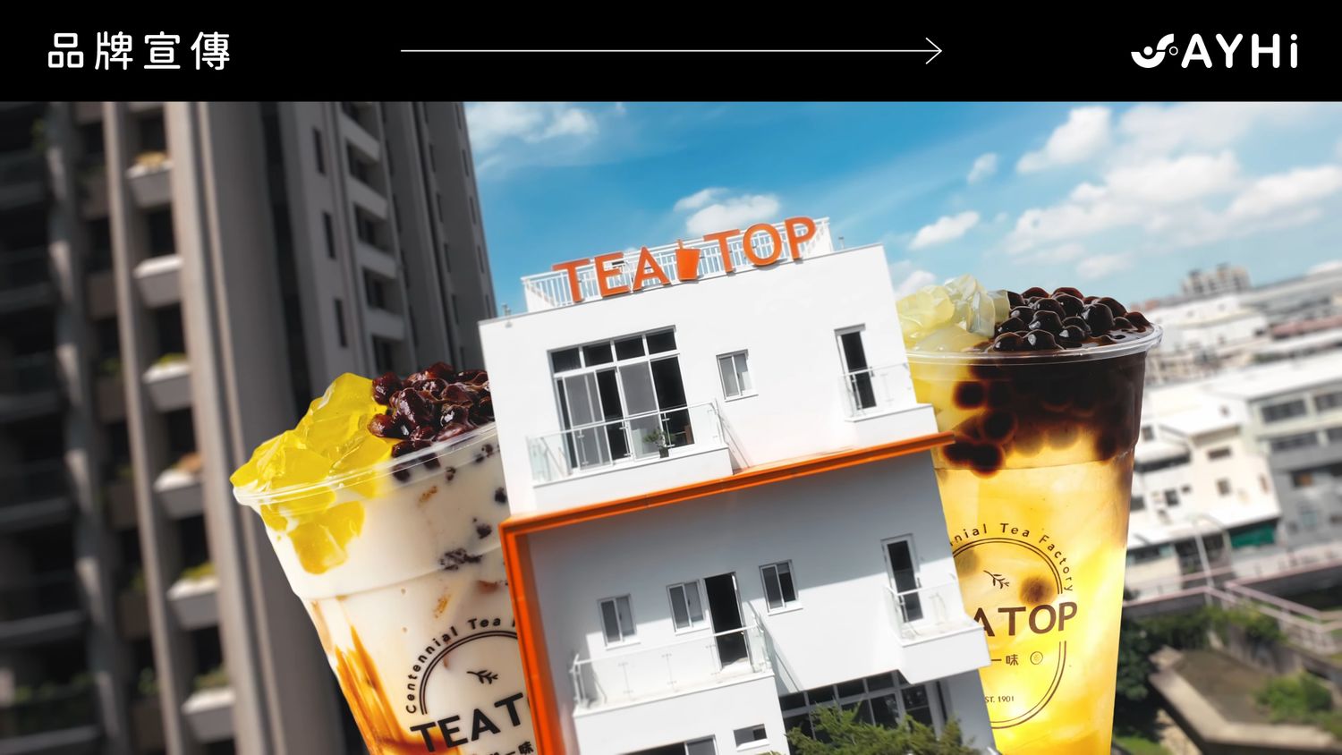TEA TOP bubble tea shop building with two large drinks featuring boba and fruit tea in an urban cityscape.